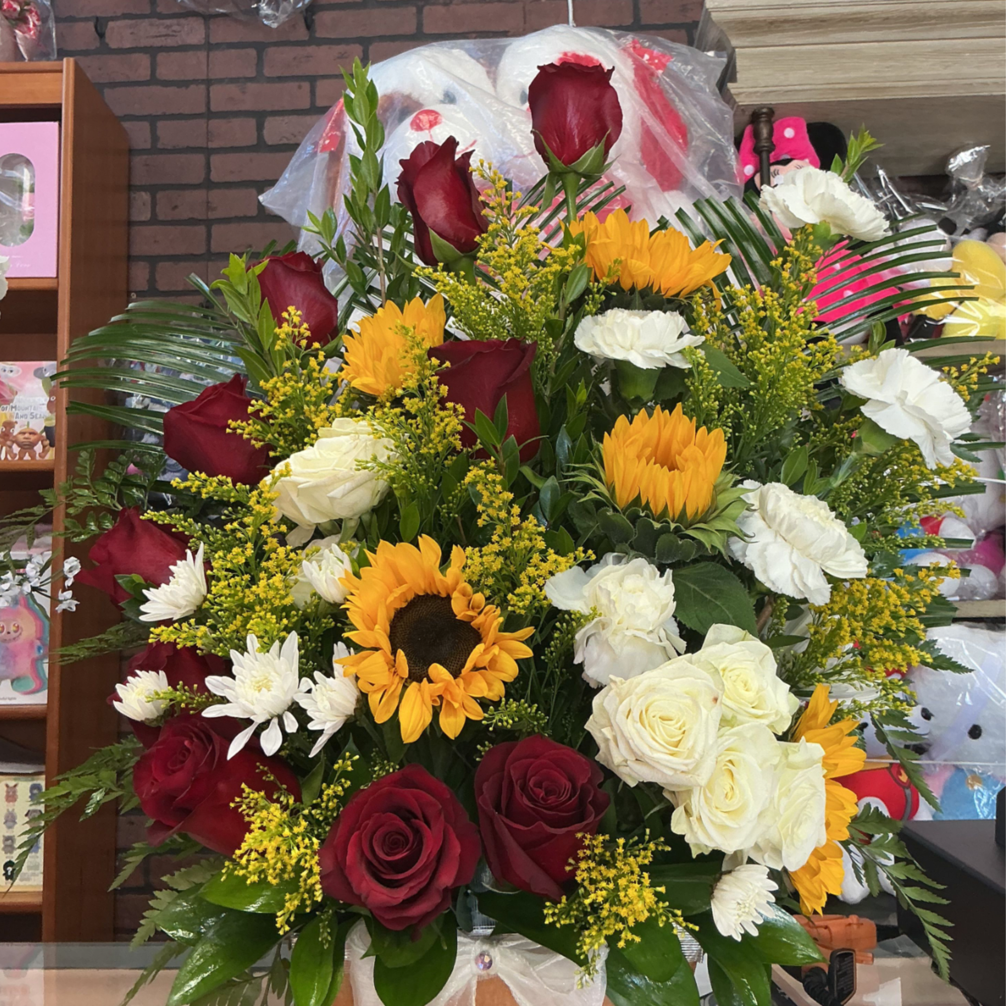 This big arrengment is made of red roses and some beautiful sunflowers