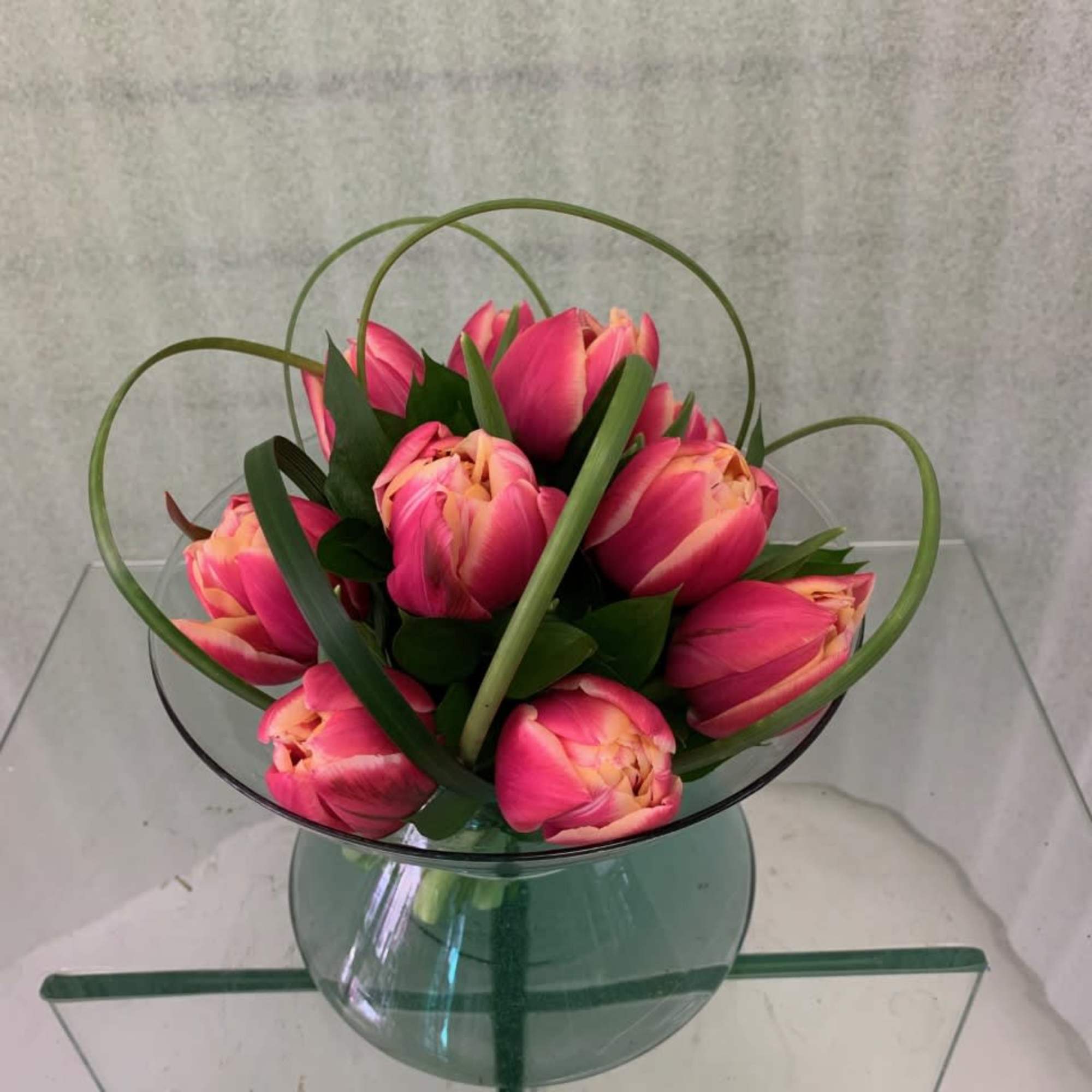 Hand-tied cluster of double tulips in a short bowl, cube or cylinder