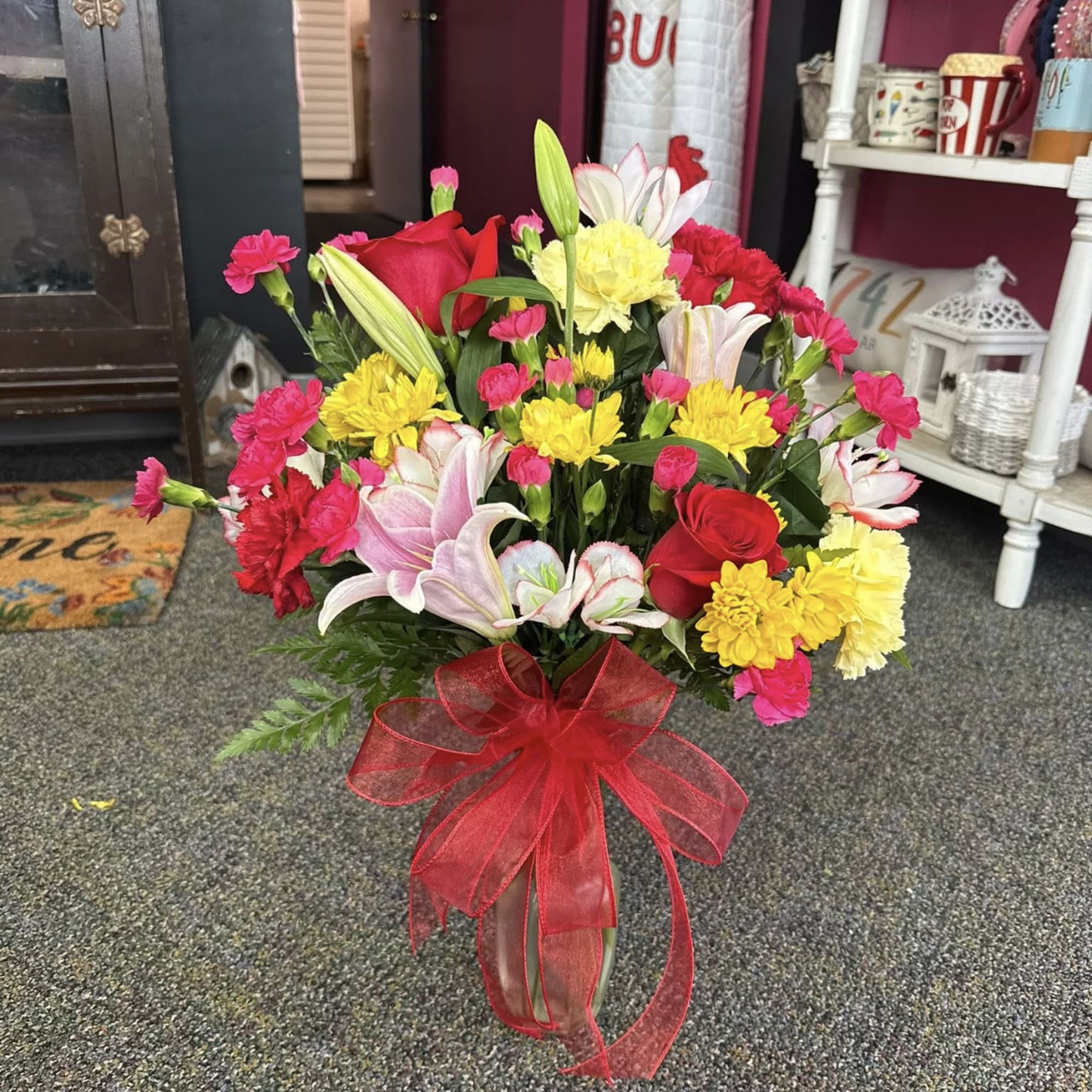 A charming mix of fresh Valentine blooms arranged in a clear glass