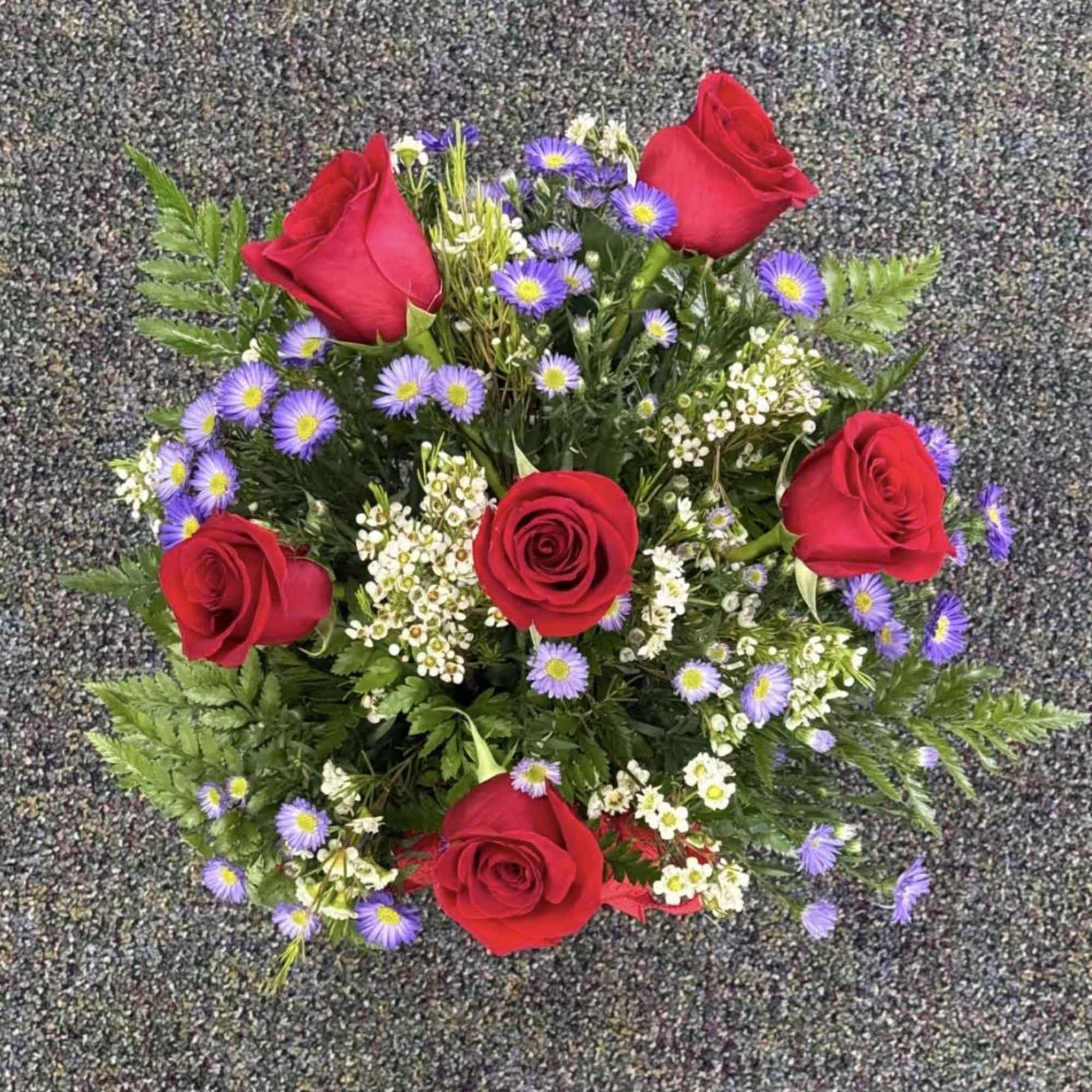 A stunning half dozen roses, hand-designed with care and wrapped or arranged