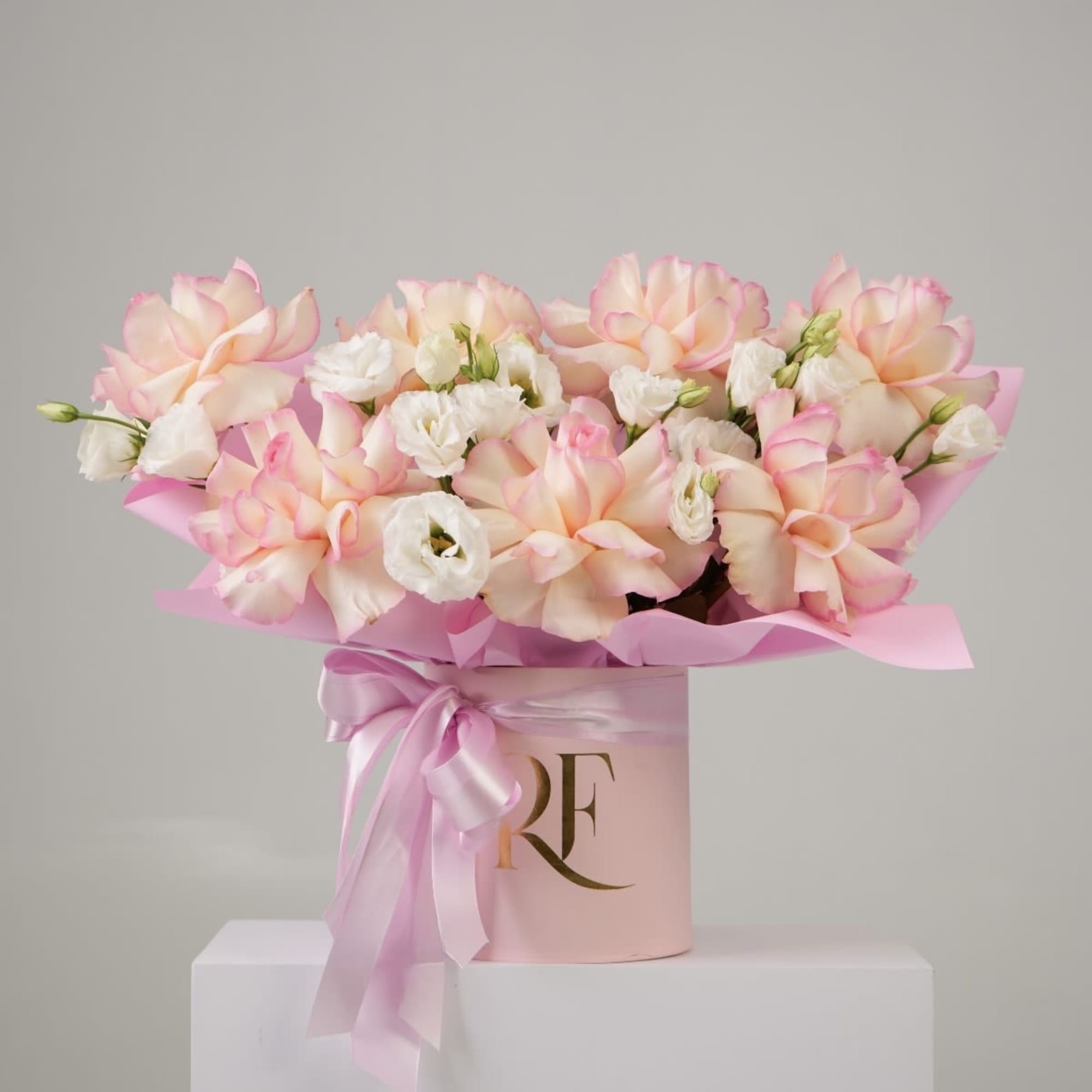 French-styled roses and lisianthus arranged in a round box.