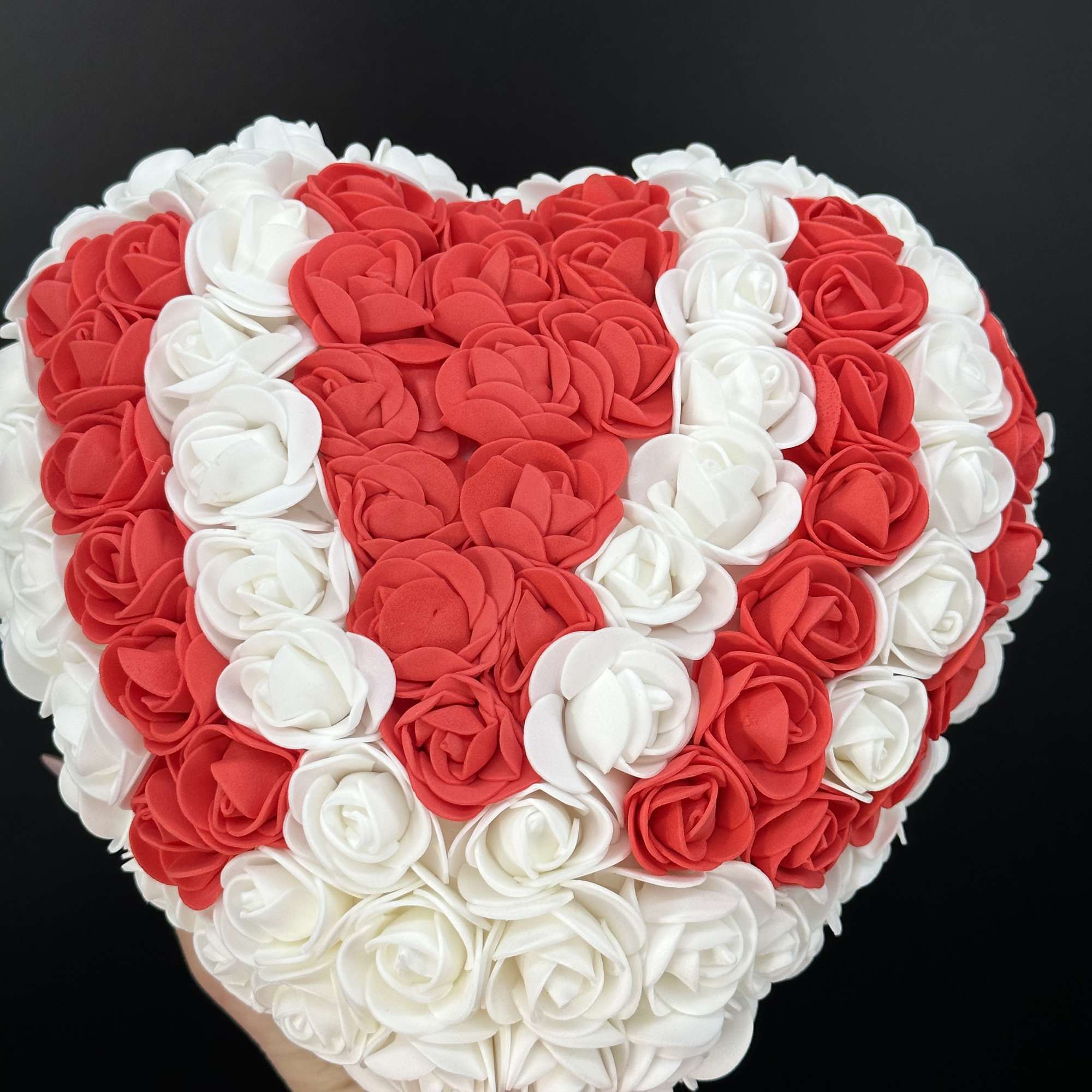 A heart shaped arrangement crafted from faux roses ,designed to symbolize everlasting