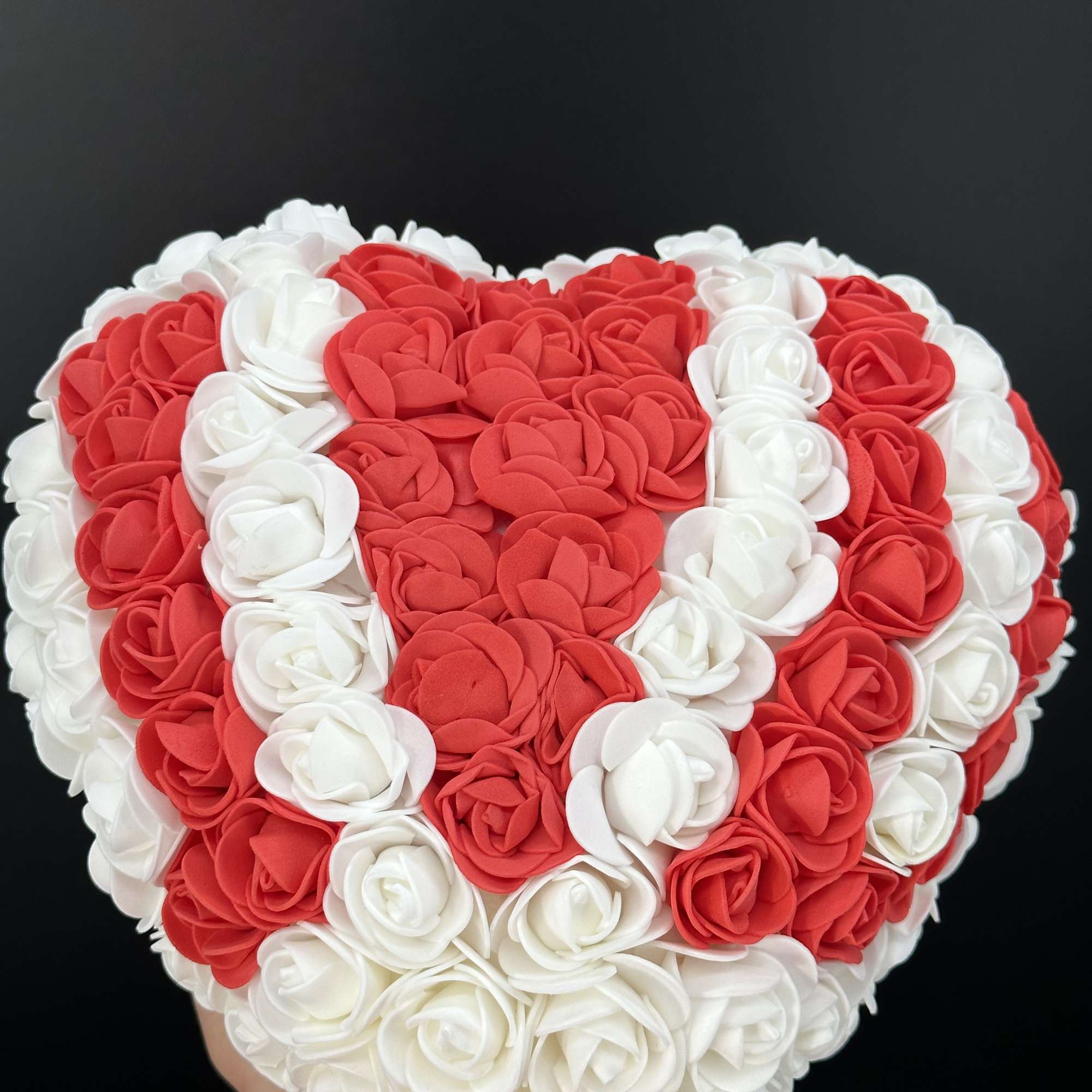 A heart shaped arrangement crafted from faux roses ,designed to symbolize everlasting