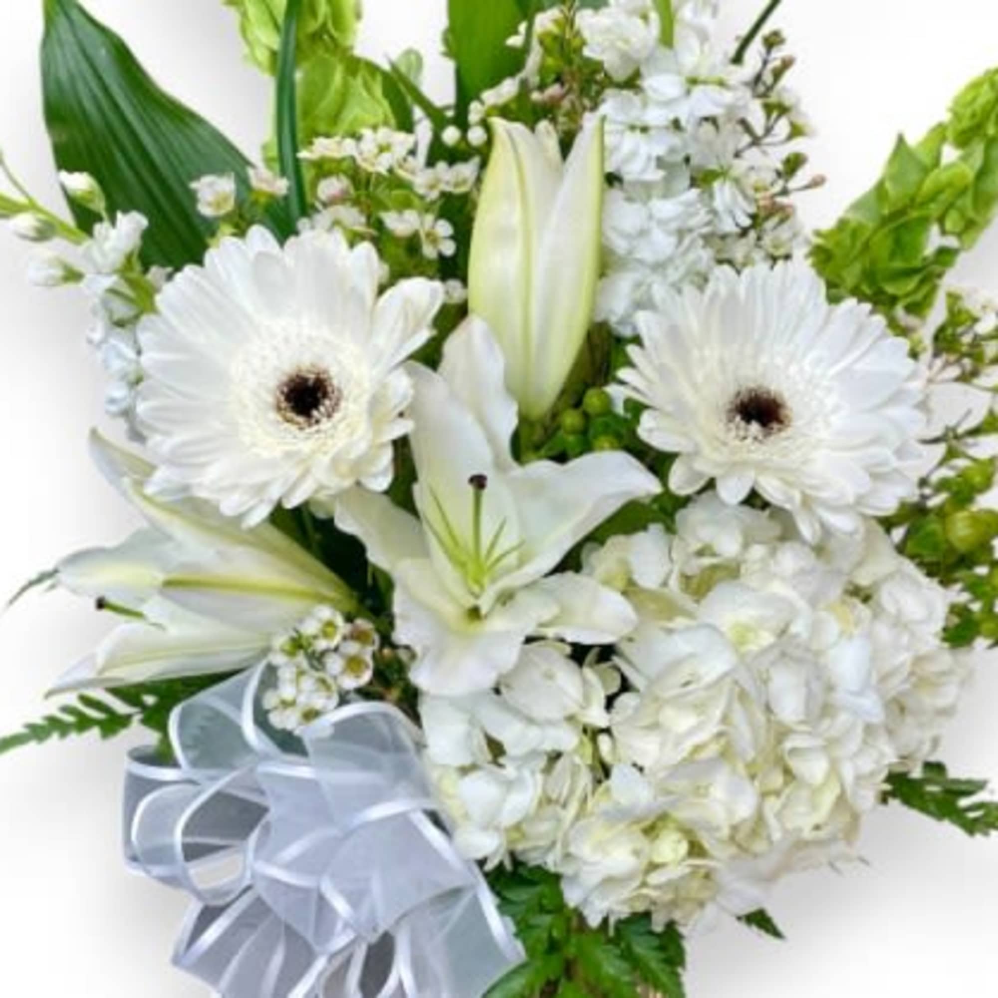 This beautiful arrangement features a selection of white flowers, including elegant lilies