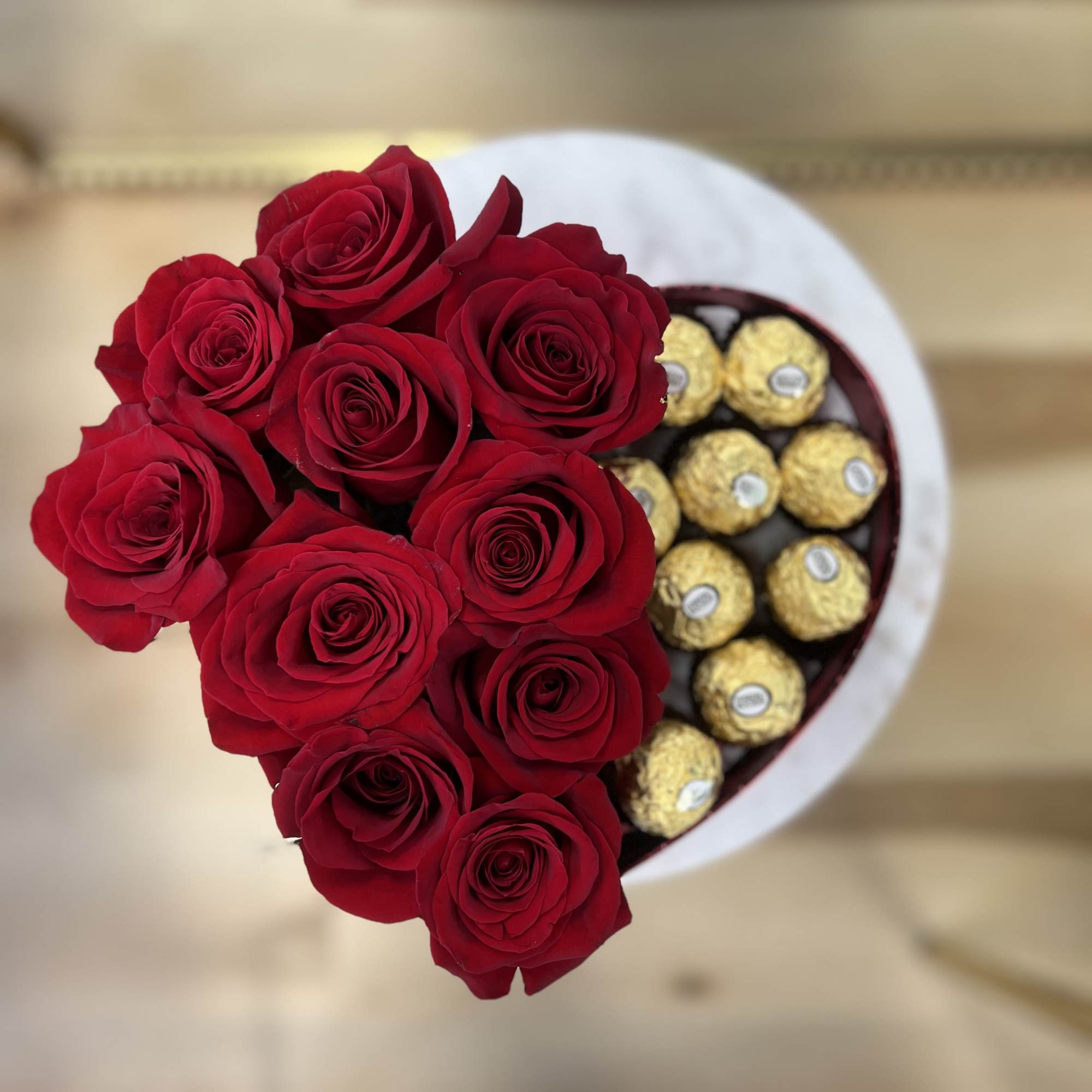 A dozen red roses and a dozen ferro rocher chocolates arranged in