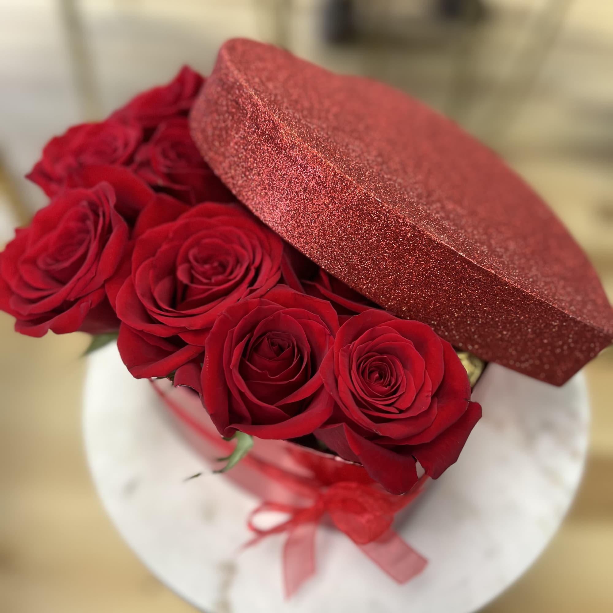 A dozen red roses and a dozen ferro rocher chocolates arranged in