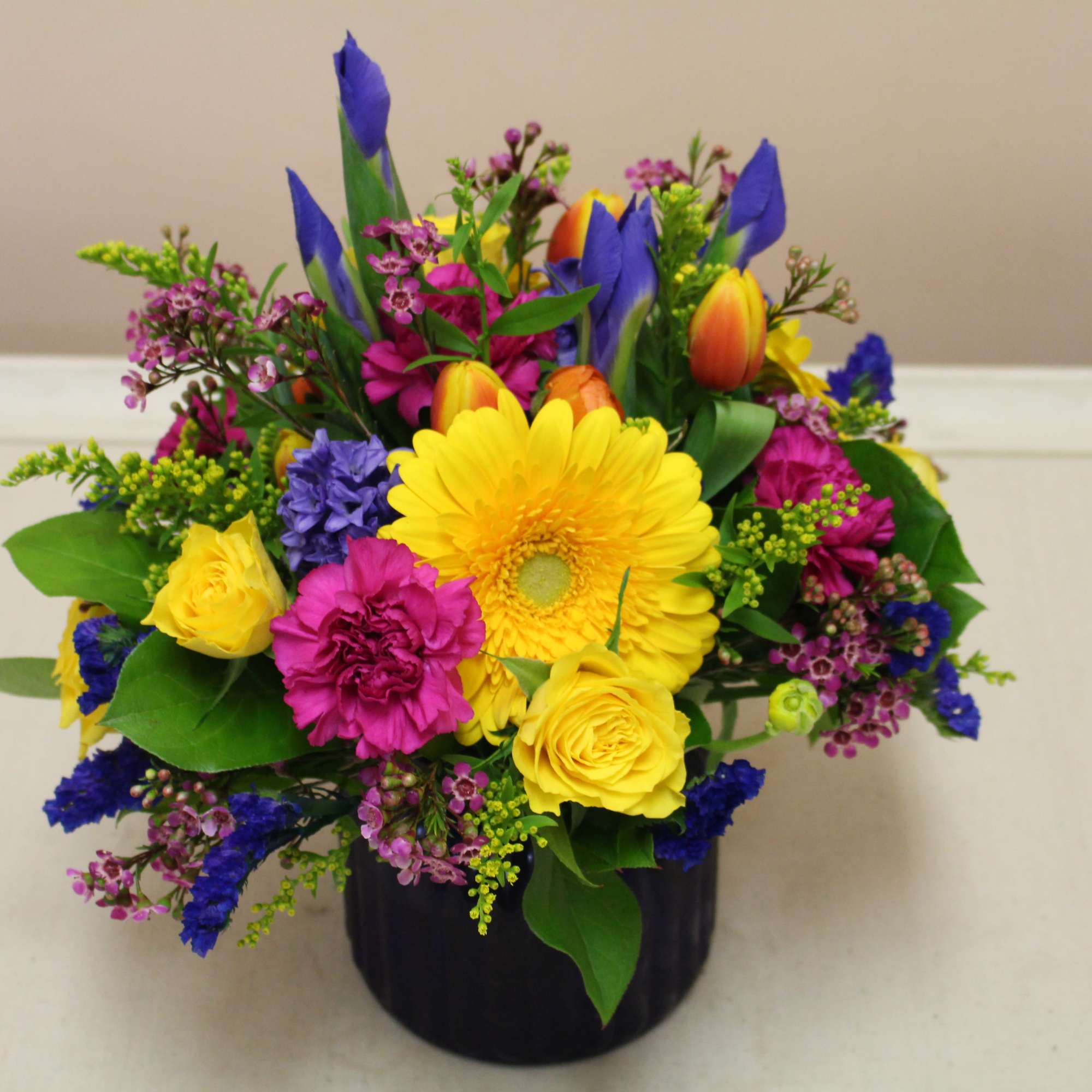 fresh arrangement in a blue cobalt vase filled with spring flowers