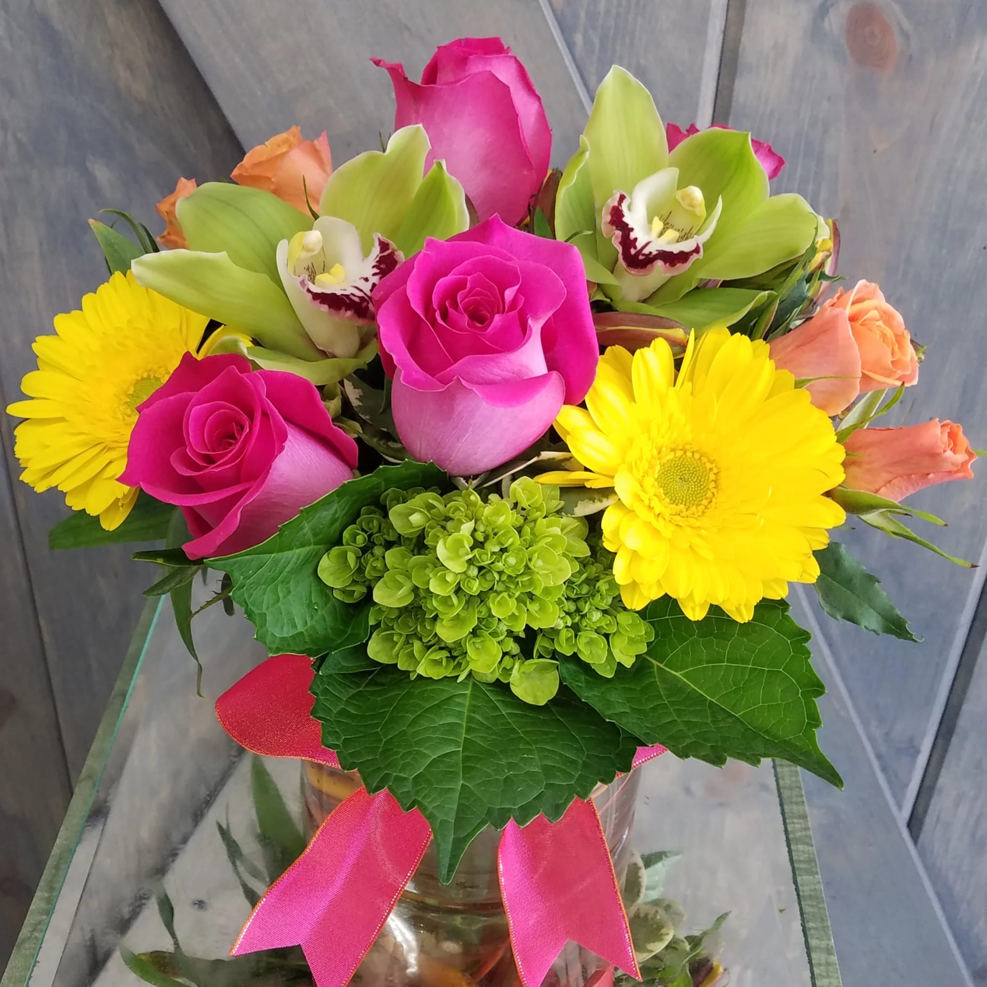 This arrangement include Roses,Spray Roses, Mini Green Hydrangea, Gerbera Daisy, Cymbidium Orchids