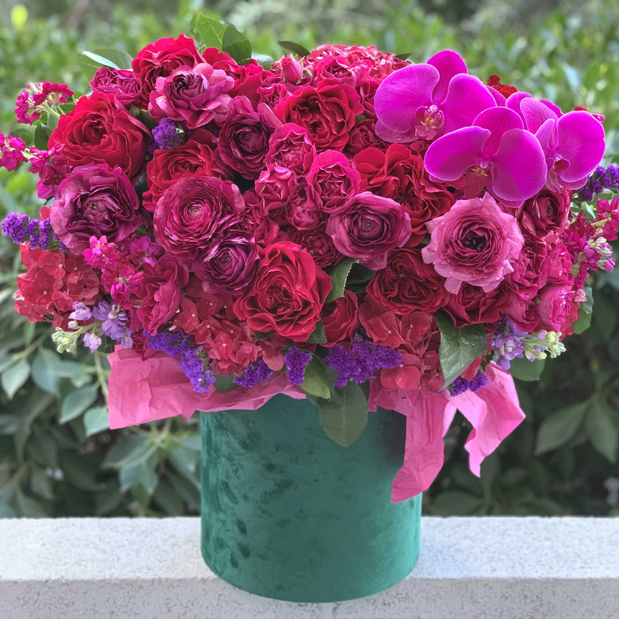 Gorgeous flowers of ripe cherry color and burgundy wine in an emerald