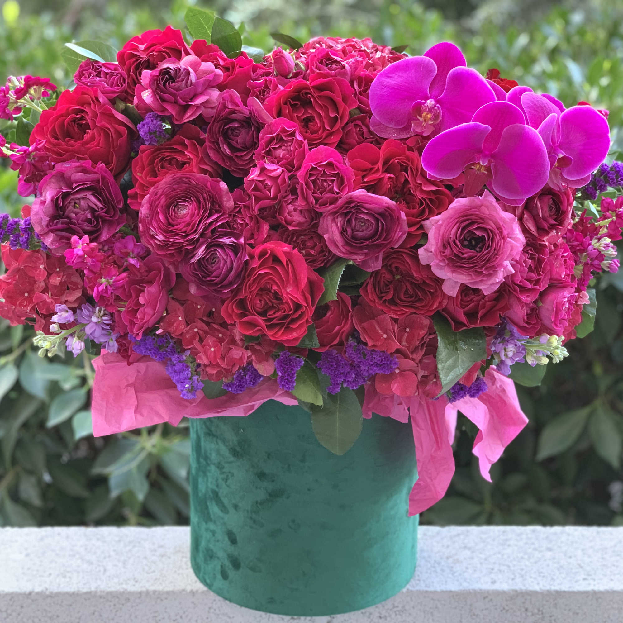 Gorgeous flowers of ripe cherry color and burgundy wine in an emerald