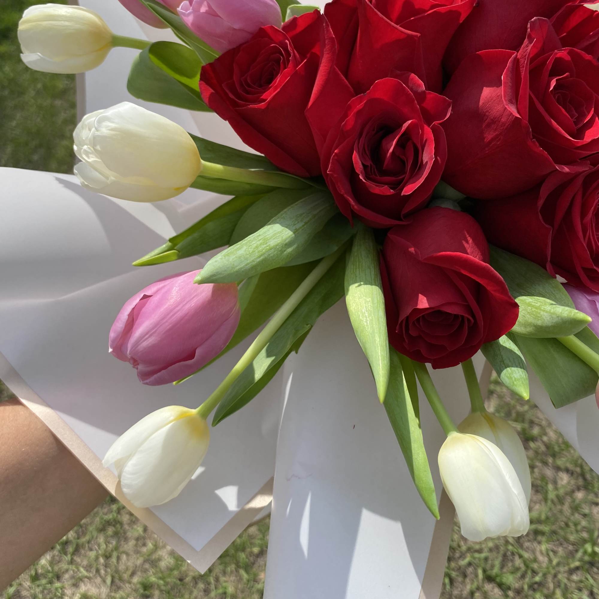 Beautiful dozen red roses with white and pink tulips,wrapped.  Glass vase