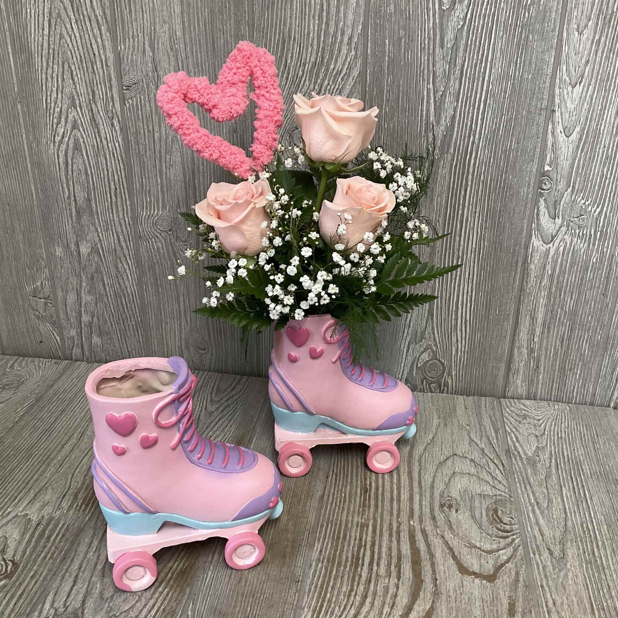 Beautiful light pink roses arranged in a keepsake ceramic roller skate container.