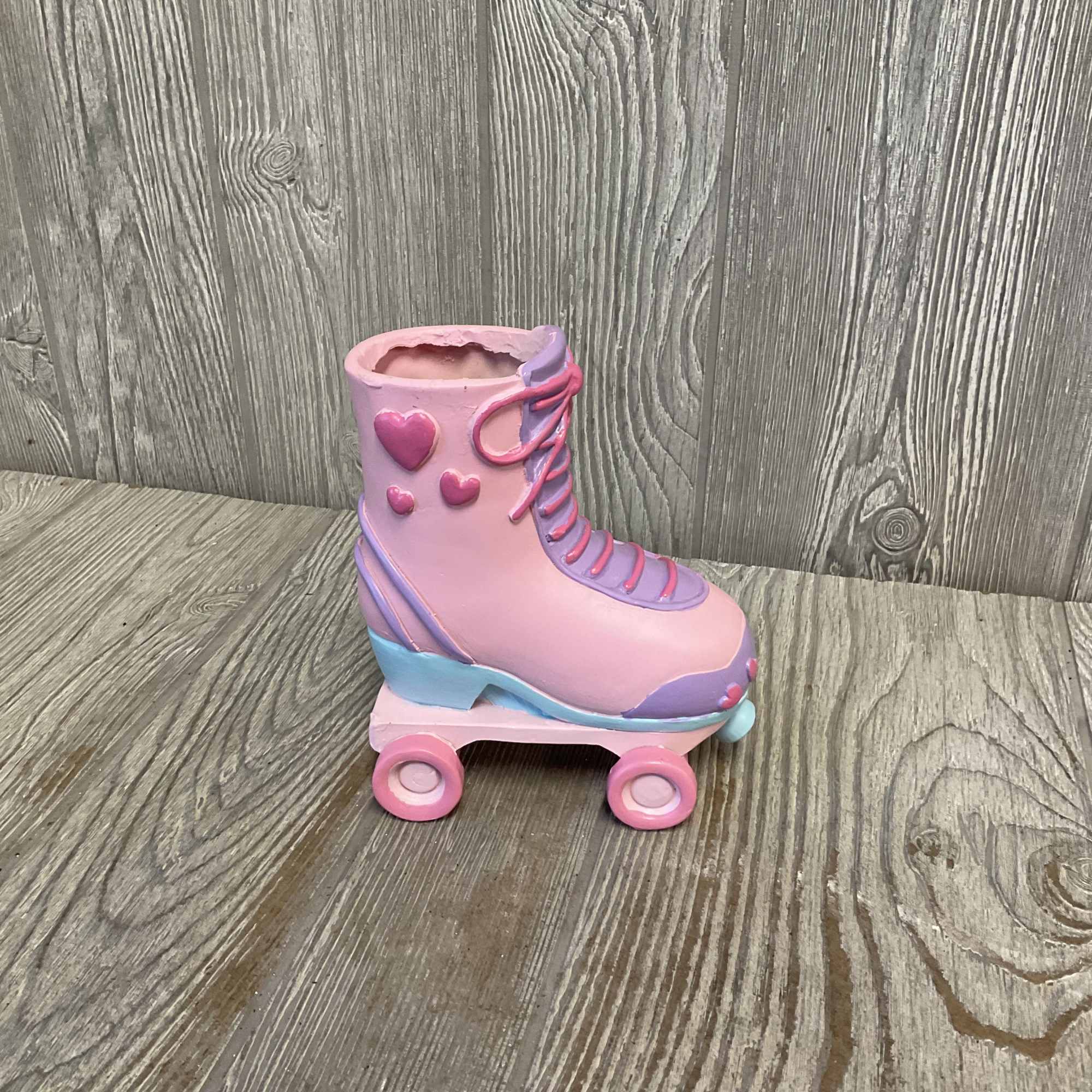 Beautiful light pink roses arranged in a keepsake ceramic roller skate container.