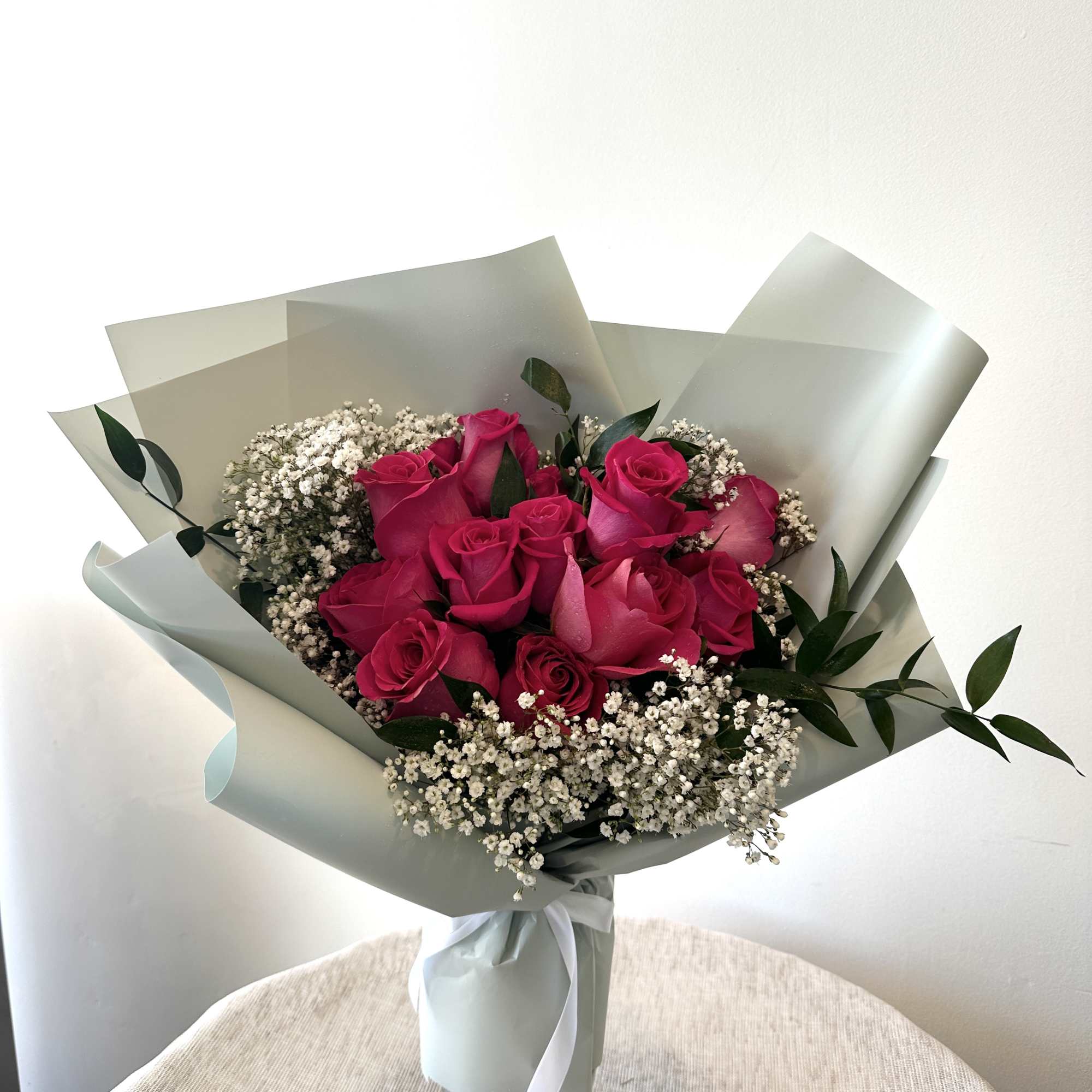 12 hot pink roses in a hand bouquet