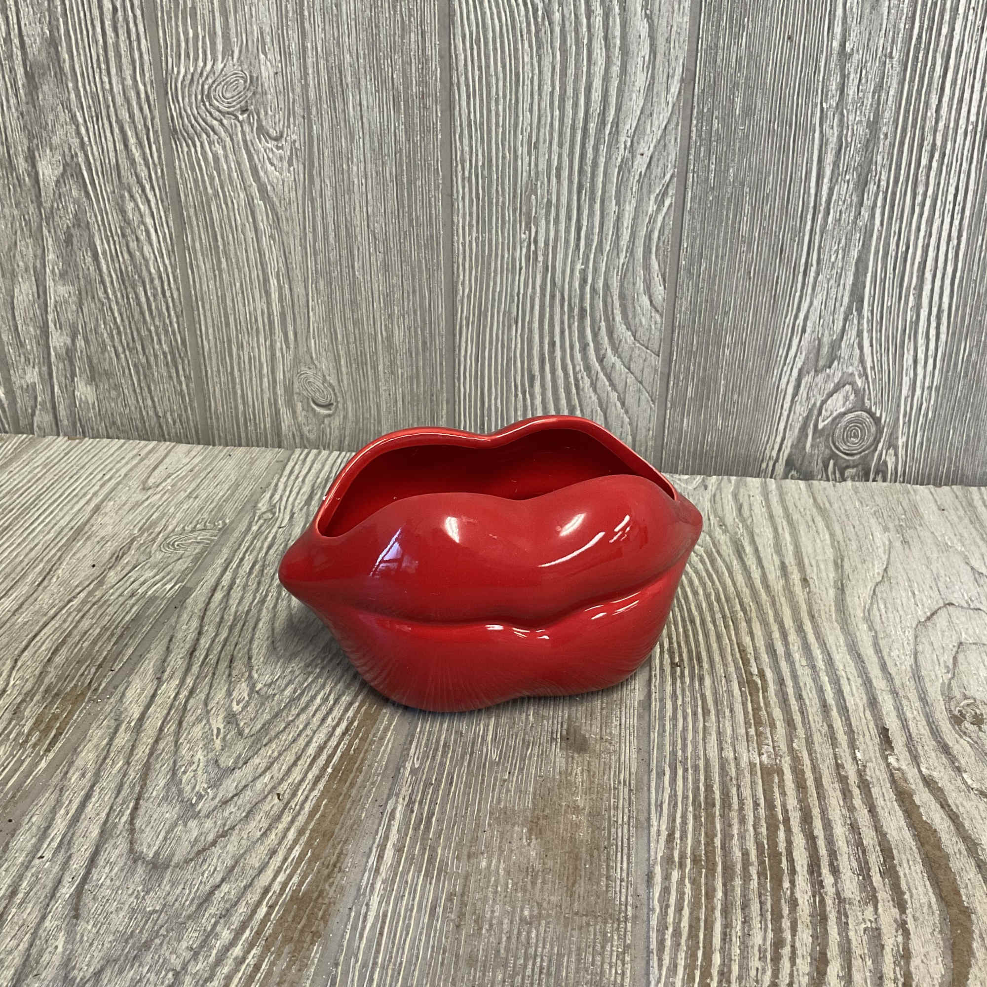 A modern elegant arrangement of red roses in a keepsake ceramic lips