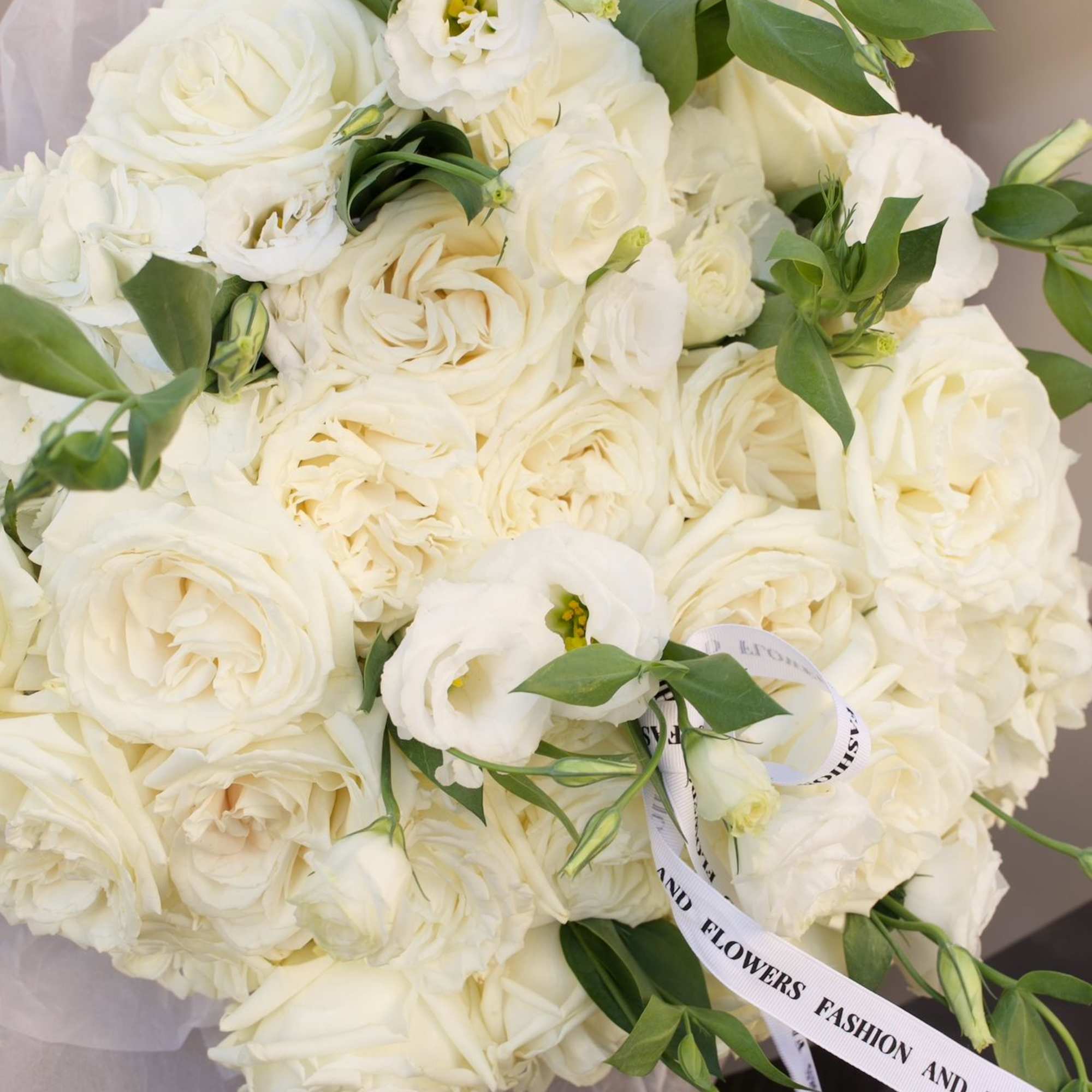 A premium all-white bouquet featuring garden roses, lisianthus, and fresh hydrangea. Designed