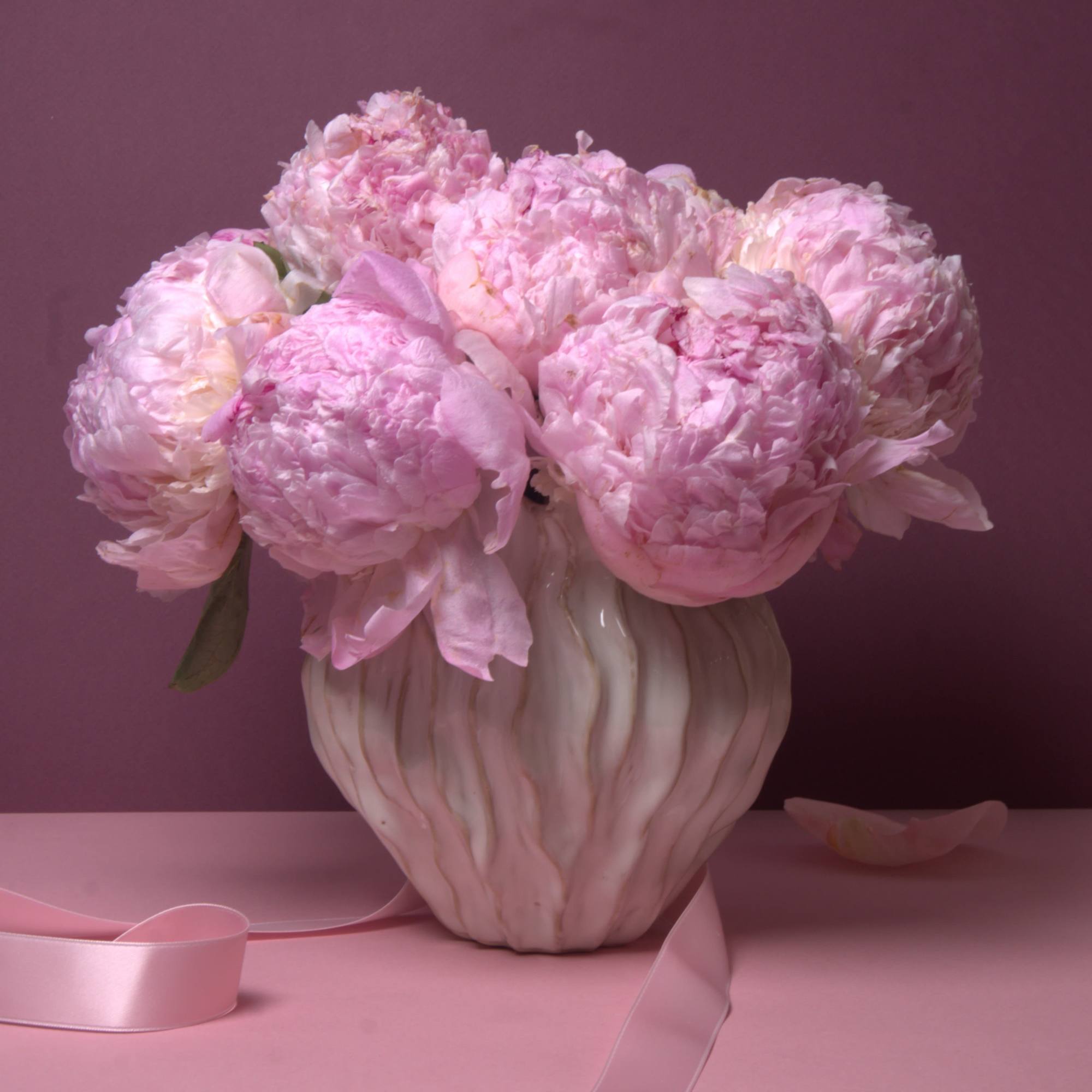 A beautiful arrangement featuring full, fragrant pink peonies gathered closely together to