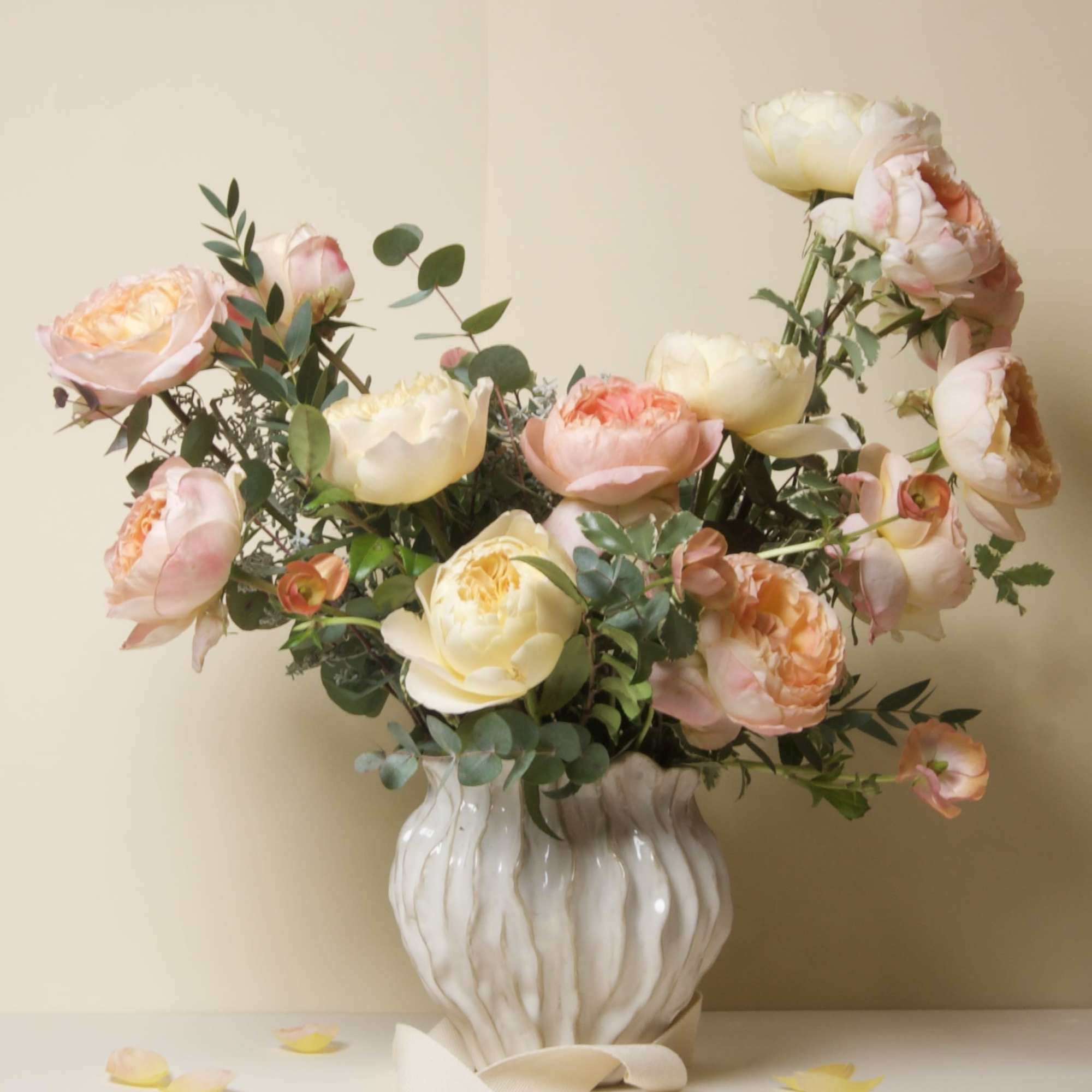 This stunning arrangement features lush garden roses in soft peach and cream