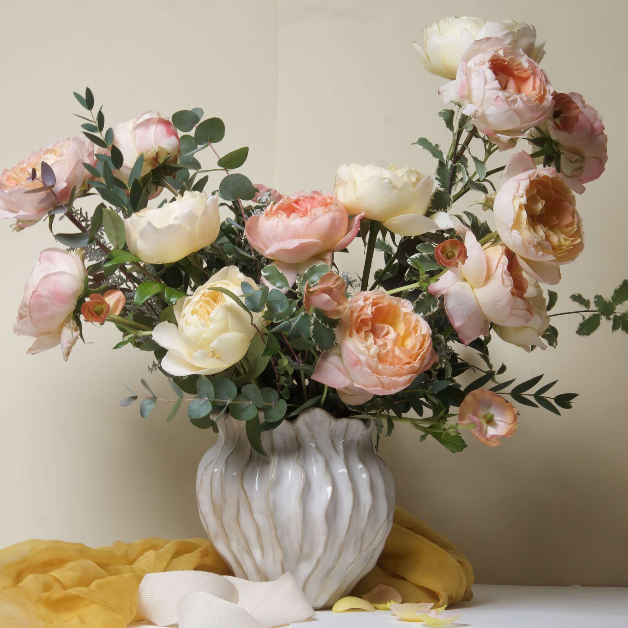 This stunning arrangement features lush garden roses in soft peach and cream