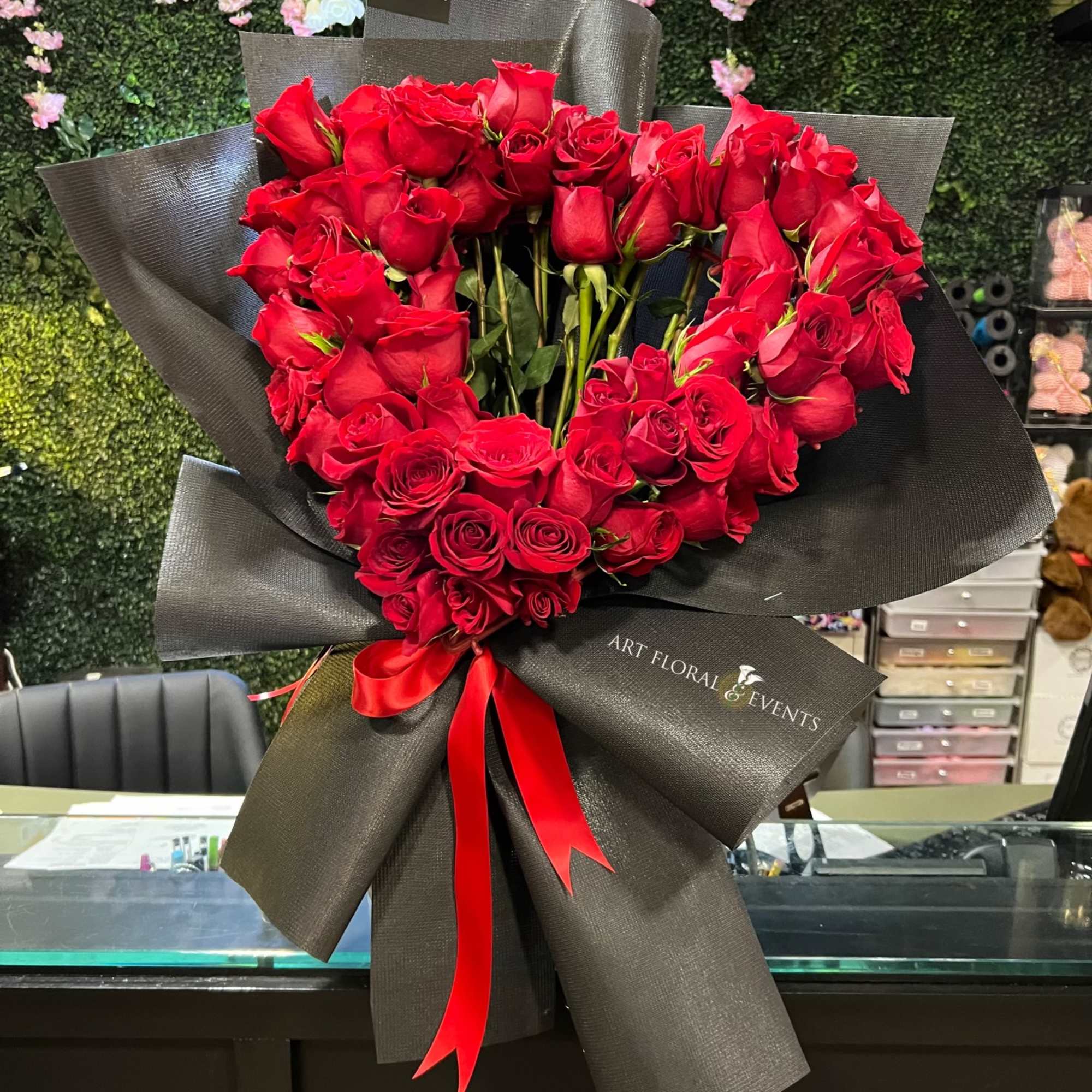 55 Natural Red Roses in the shape of a heart. 
Wrapped in