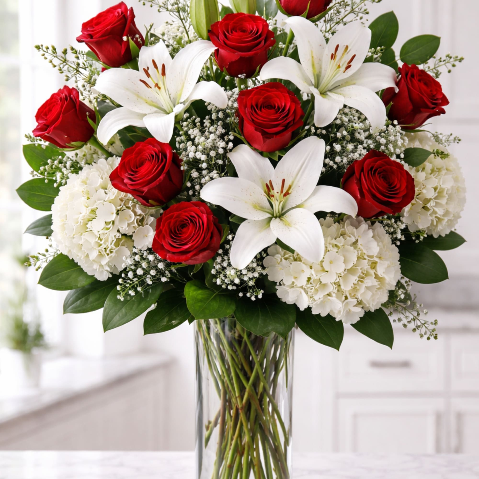 Twelve classic red roses are artfully paired with lush white hydrangea and