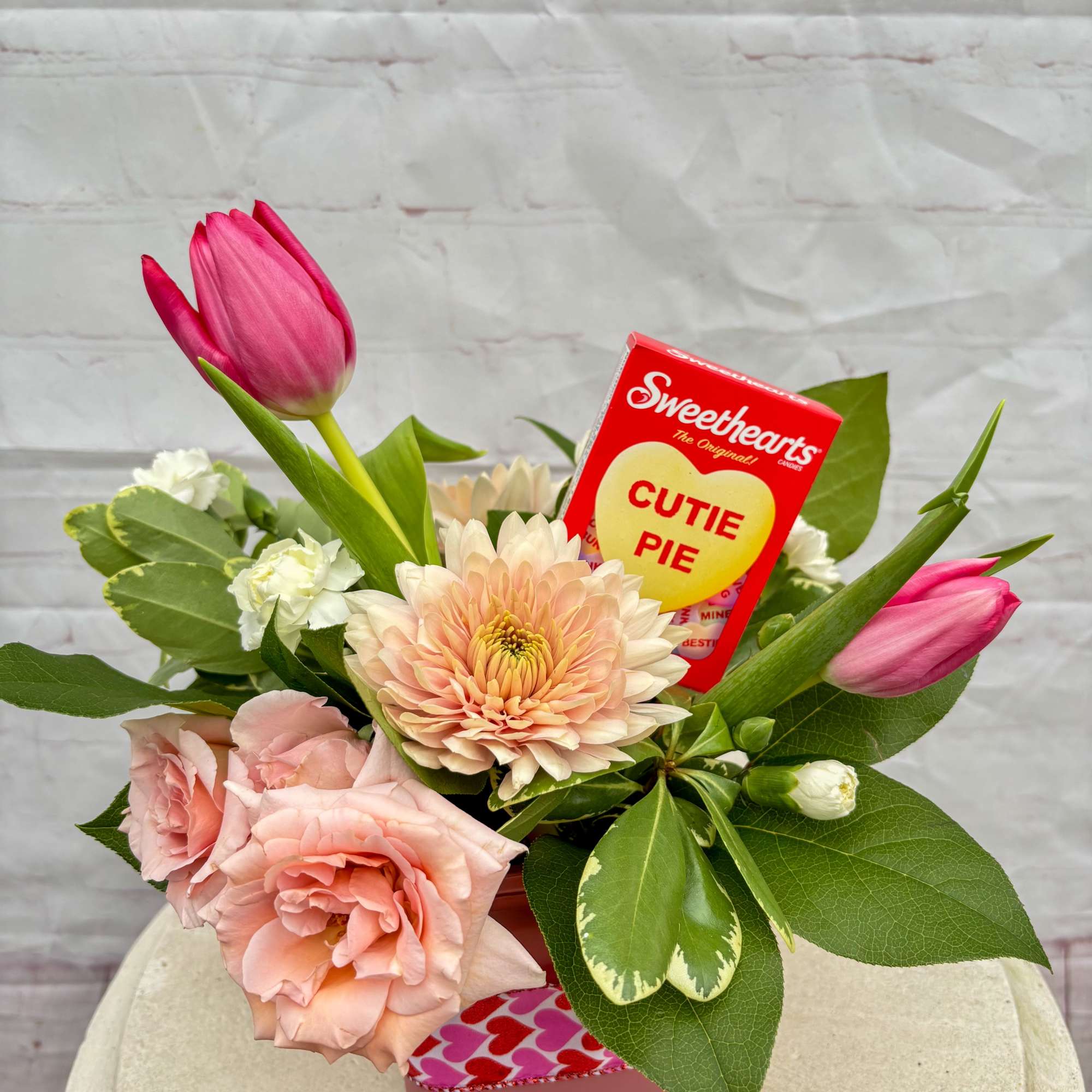 The Cutie Pie Arrangement combines soft spray roses, fresh tulips, and complementary