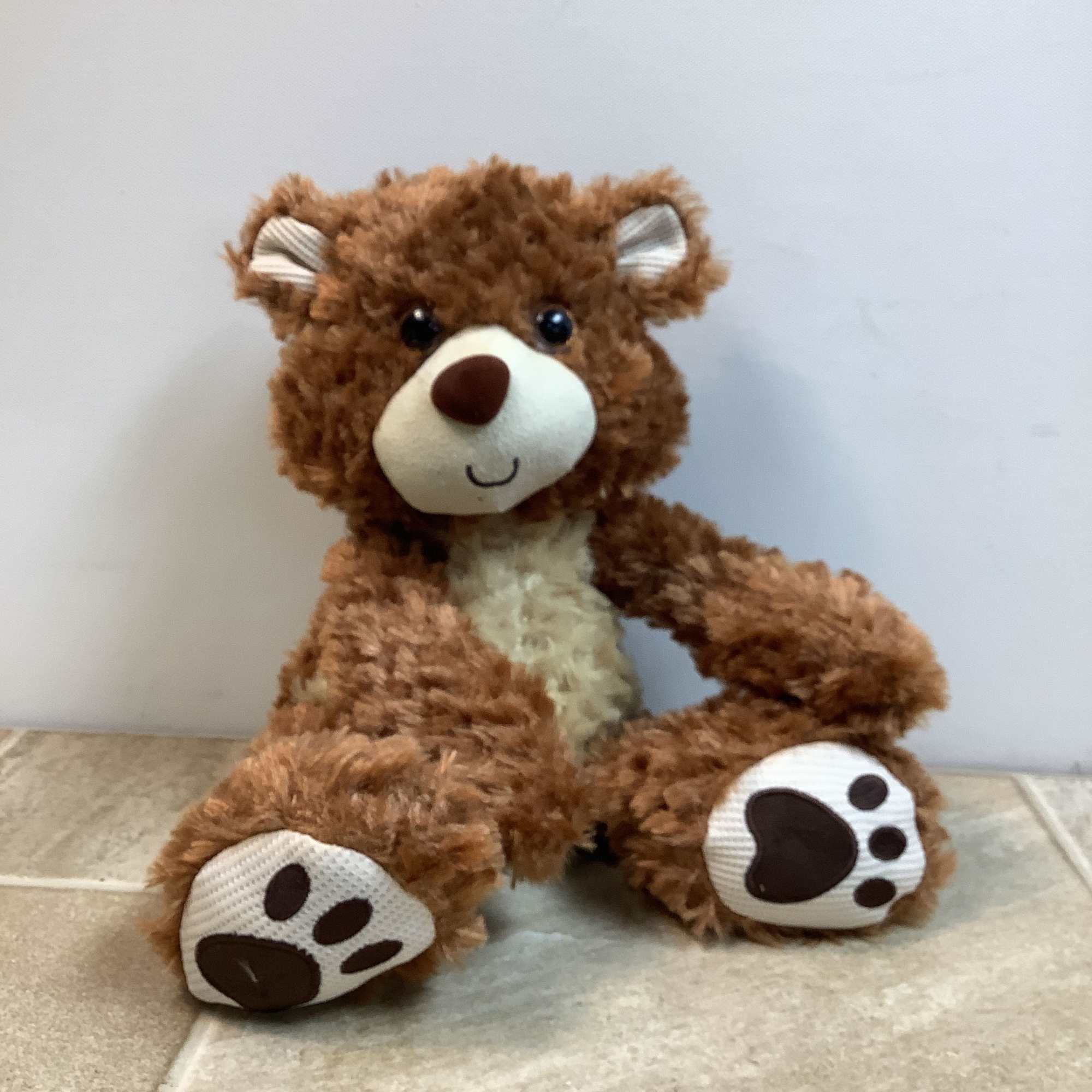 Willoughby is a very soft, brown plush bear with a happy face.