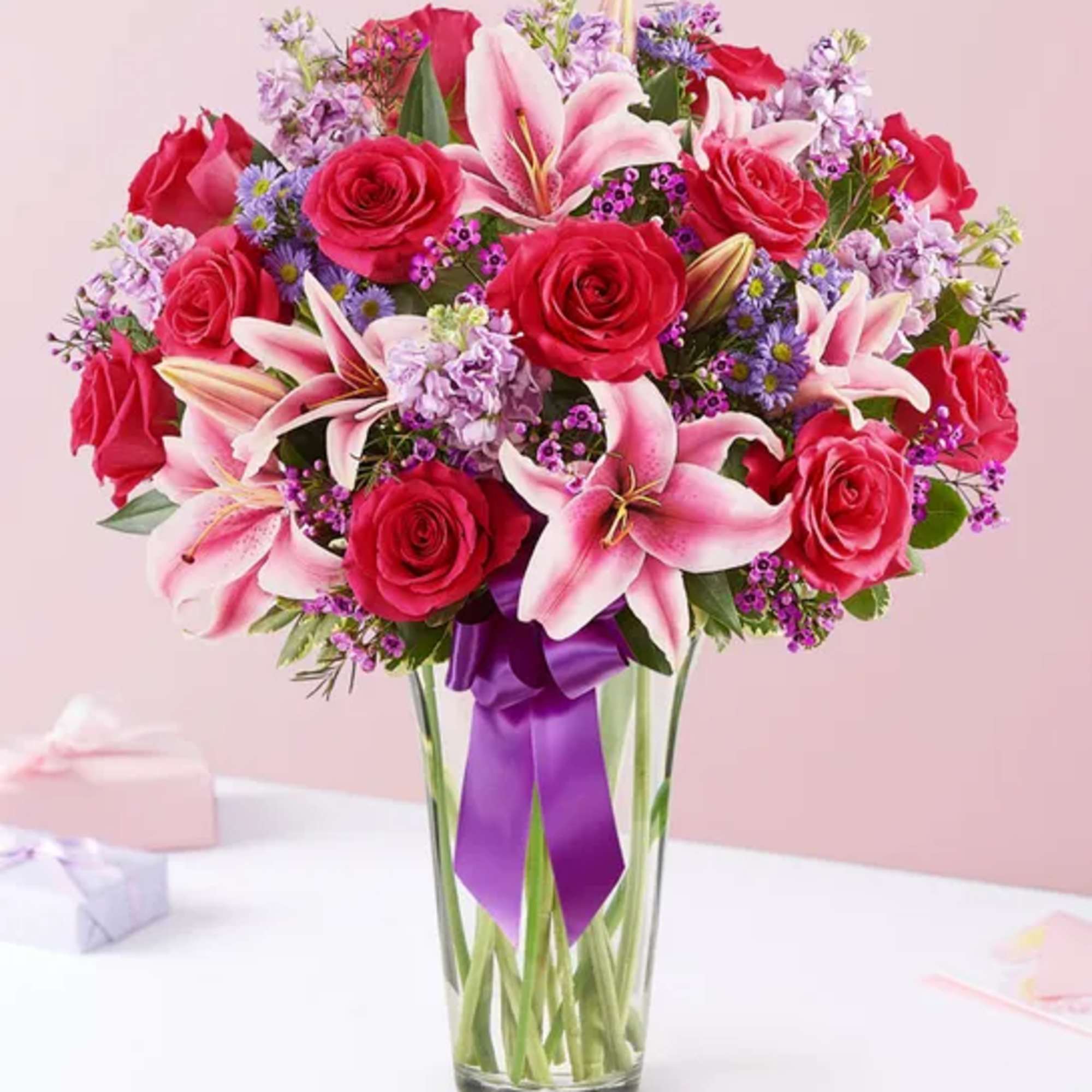 This arrangement with hot pink roses, pink Stargazer lilies, lavender stock, purple