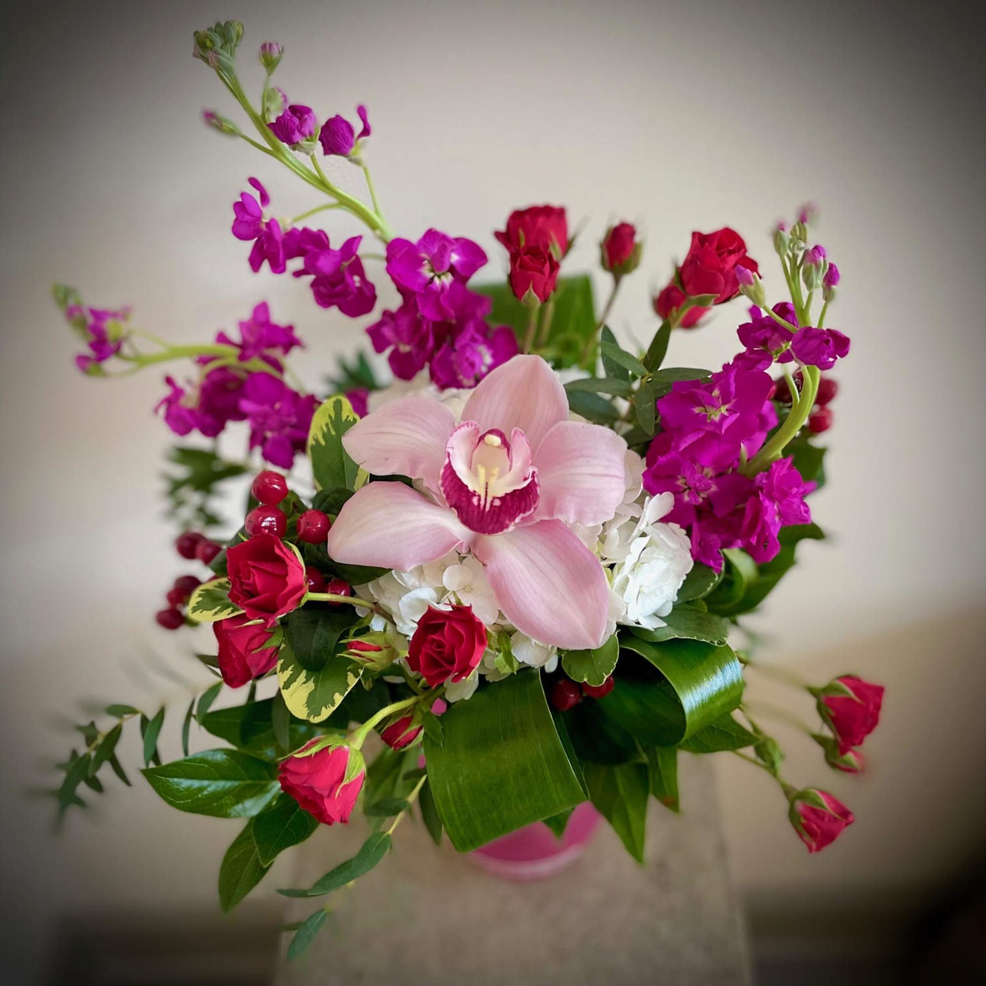 Romantic compact arrangement in shades of Pink, White and Red. Includes a