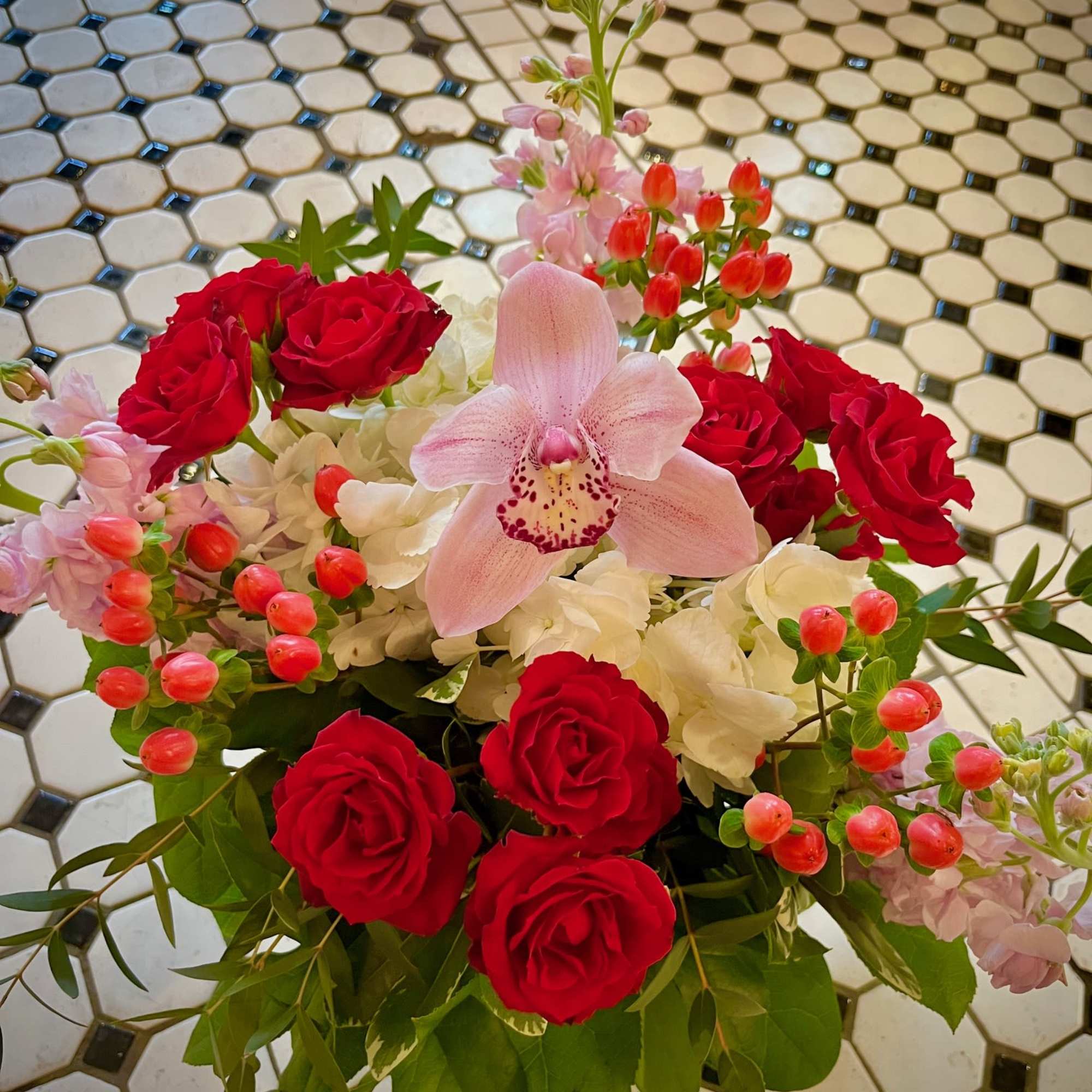 Romantic compact arrangement in shades of Pink, White and Red. Includes a