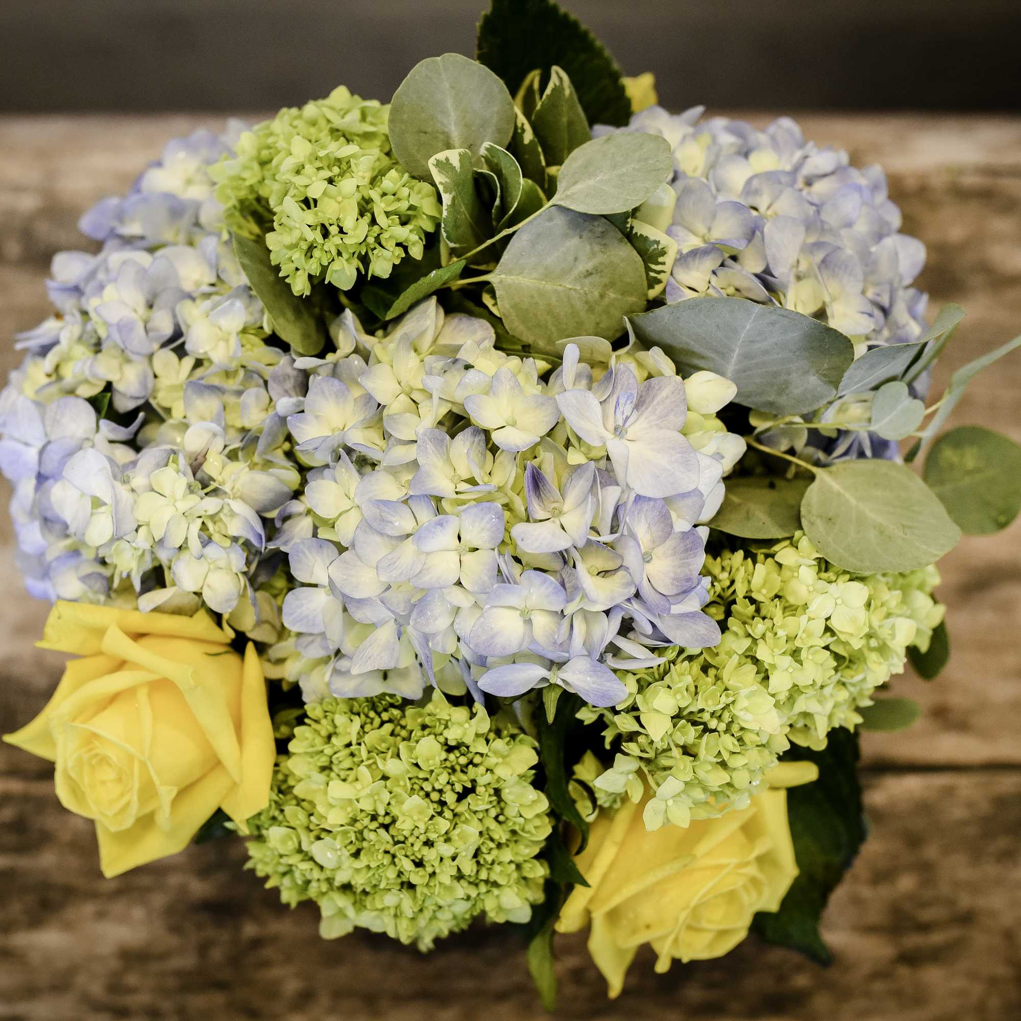 A wooden container holds beautiful, chic blooms. 