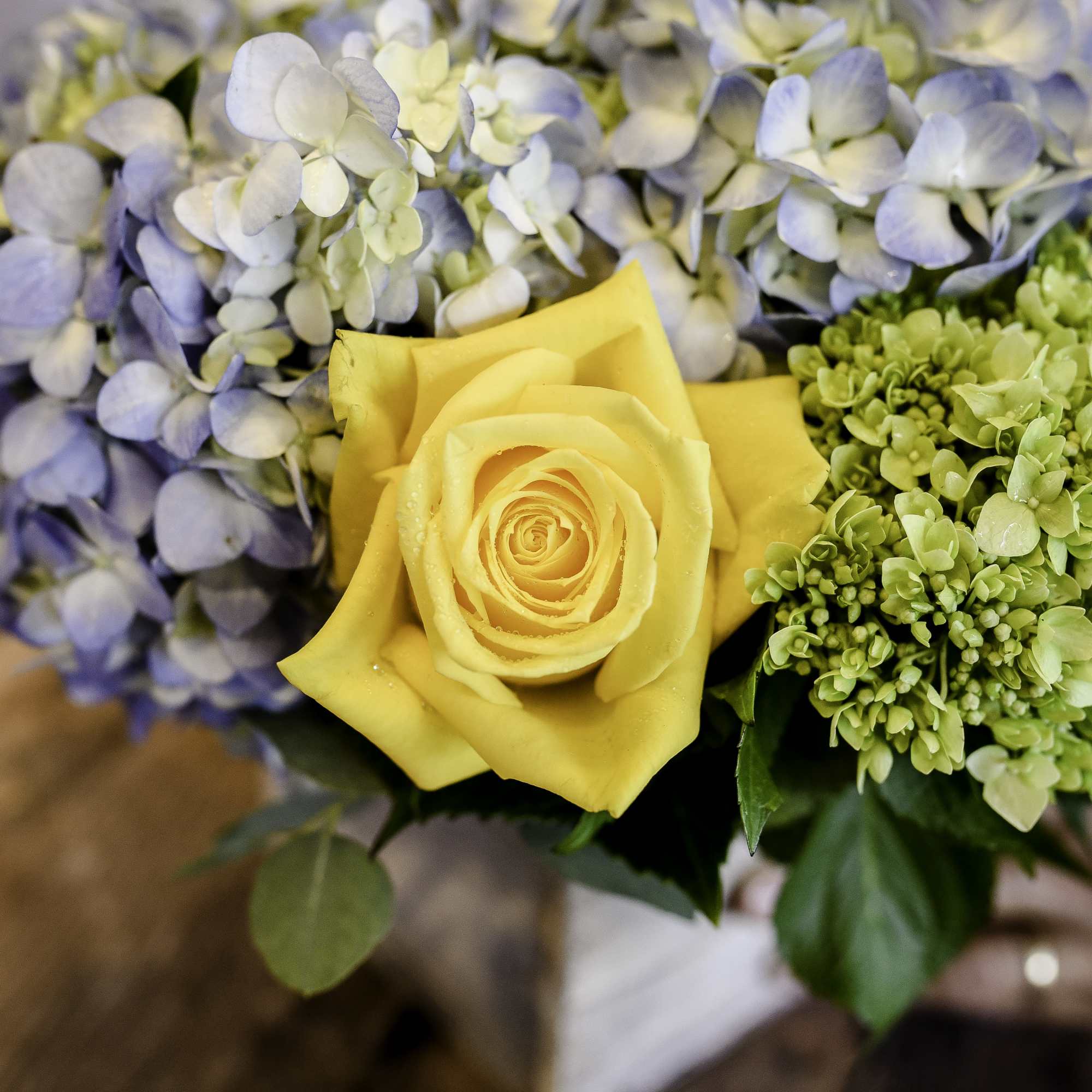 A wooden container holds beautiful, chic blooms. 