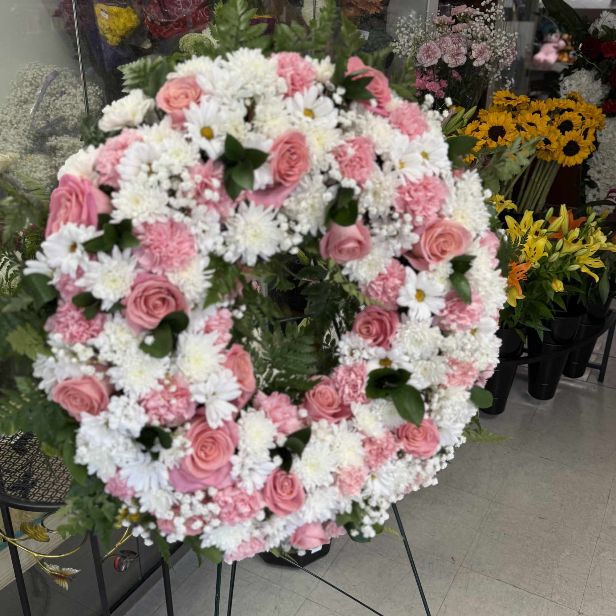 Funeral wreath in white and pink.
Corona funebre en color blanco y rosado