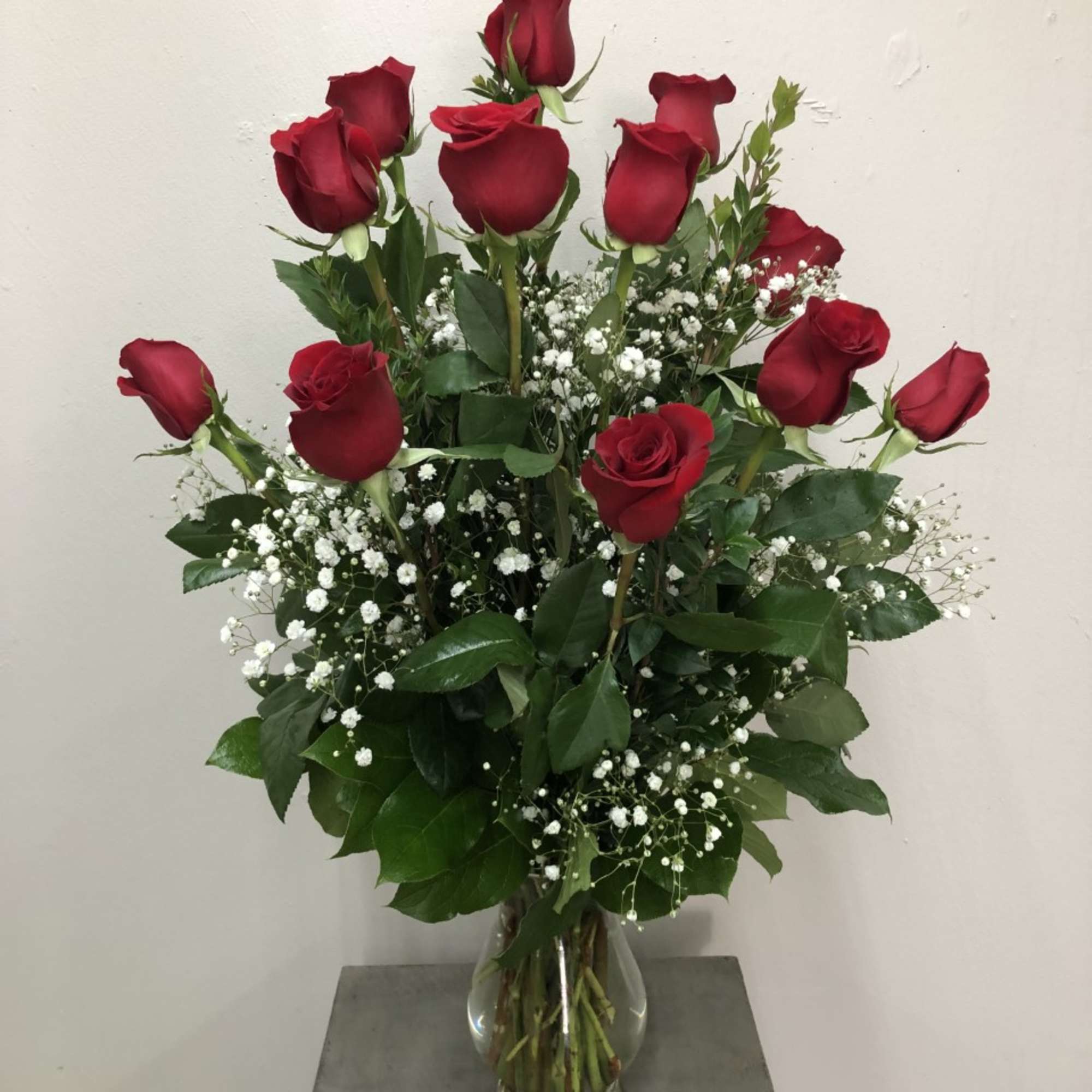 A dozen roses arranged in a vase by our expert designers, dressed