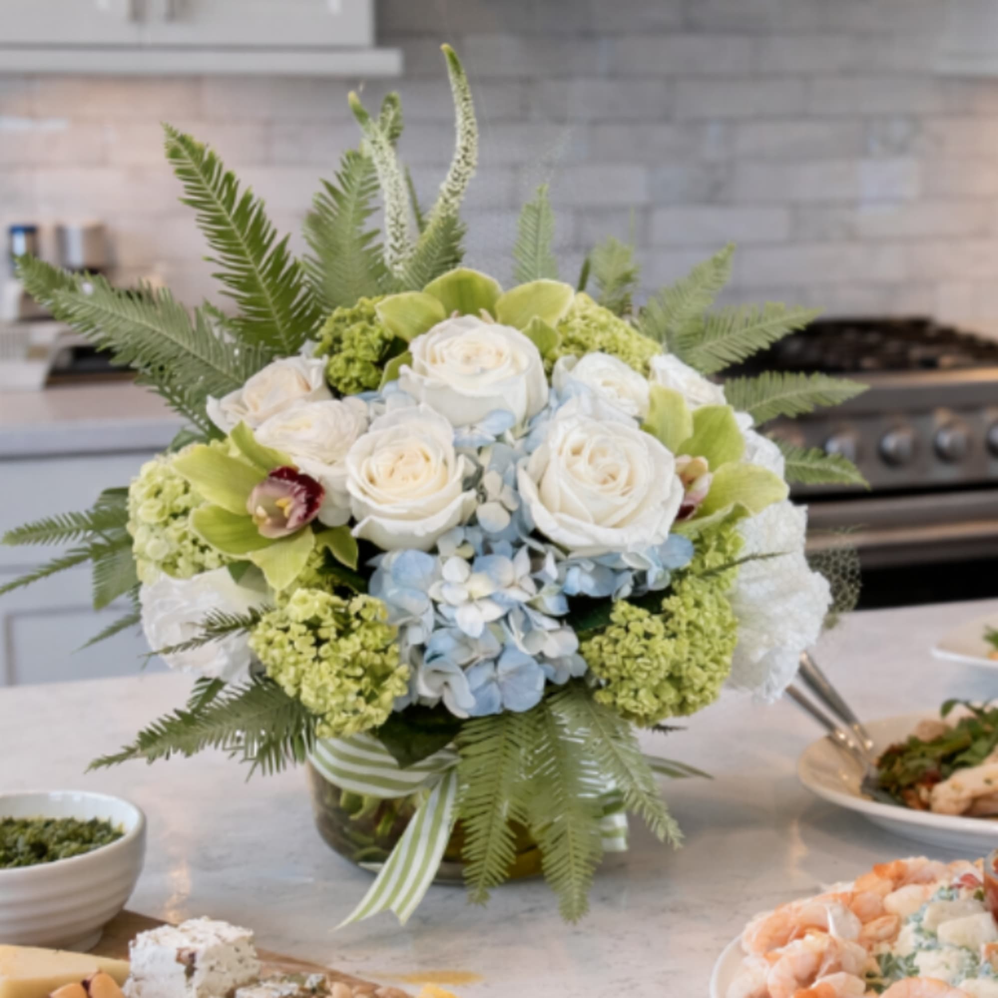 This beautiful arrangement including Hydrangea, Roses, Cymbidium Orchids, Ranunculus, Veronica, Lisianthus, Mini