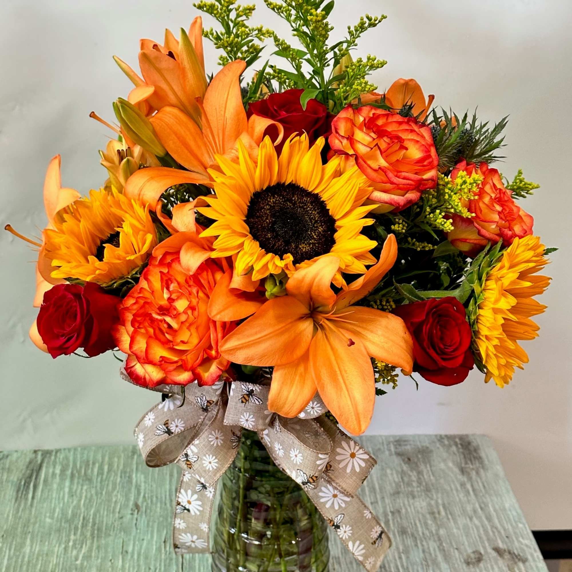 Arrangement of fresh cut flowers designed in a glass vase. Colors can