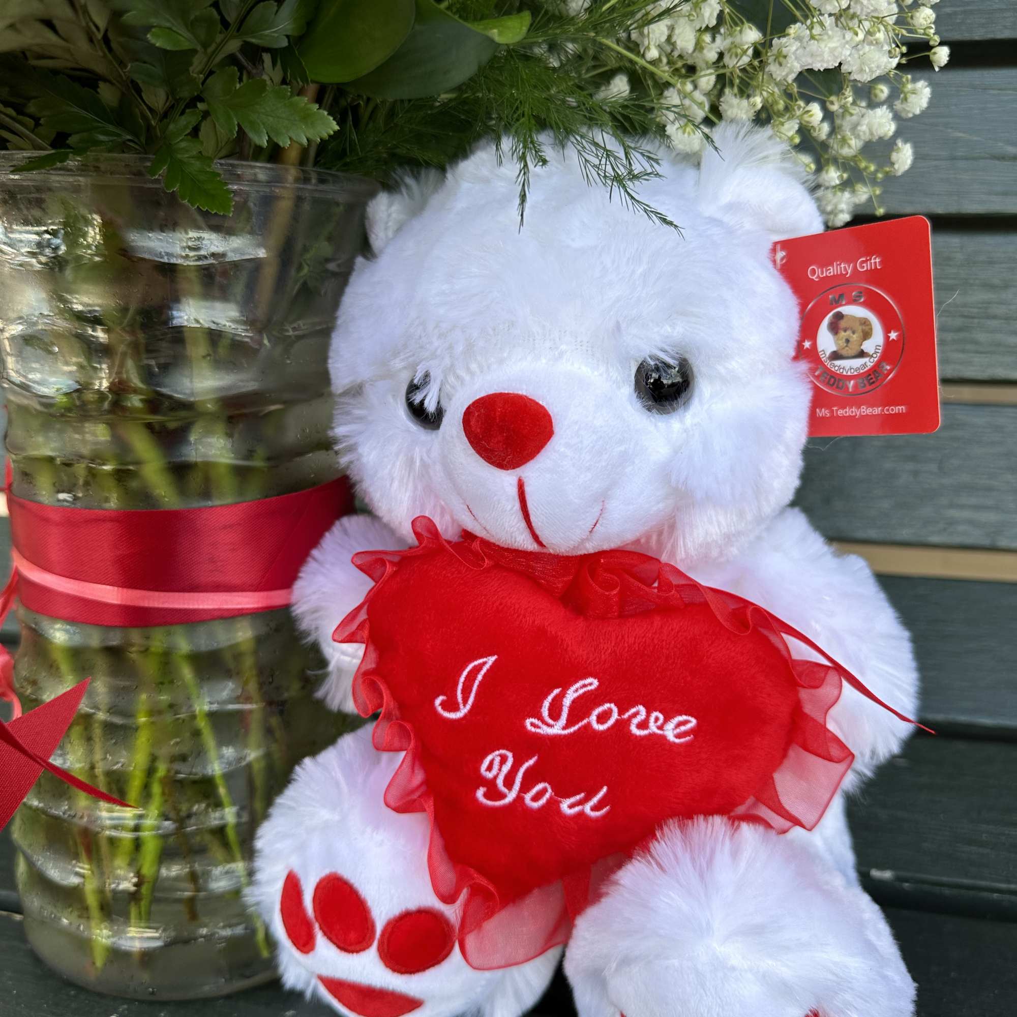 a dozen beautiful red roses arranged with a little green and a