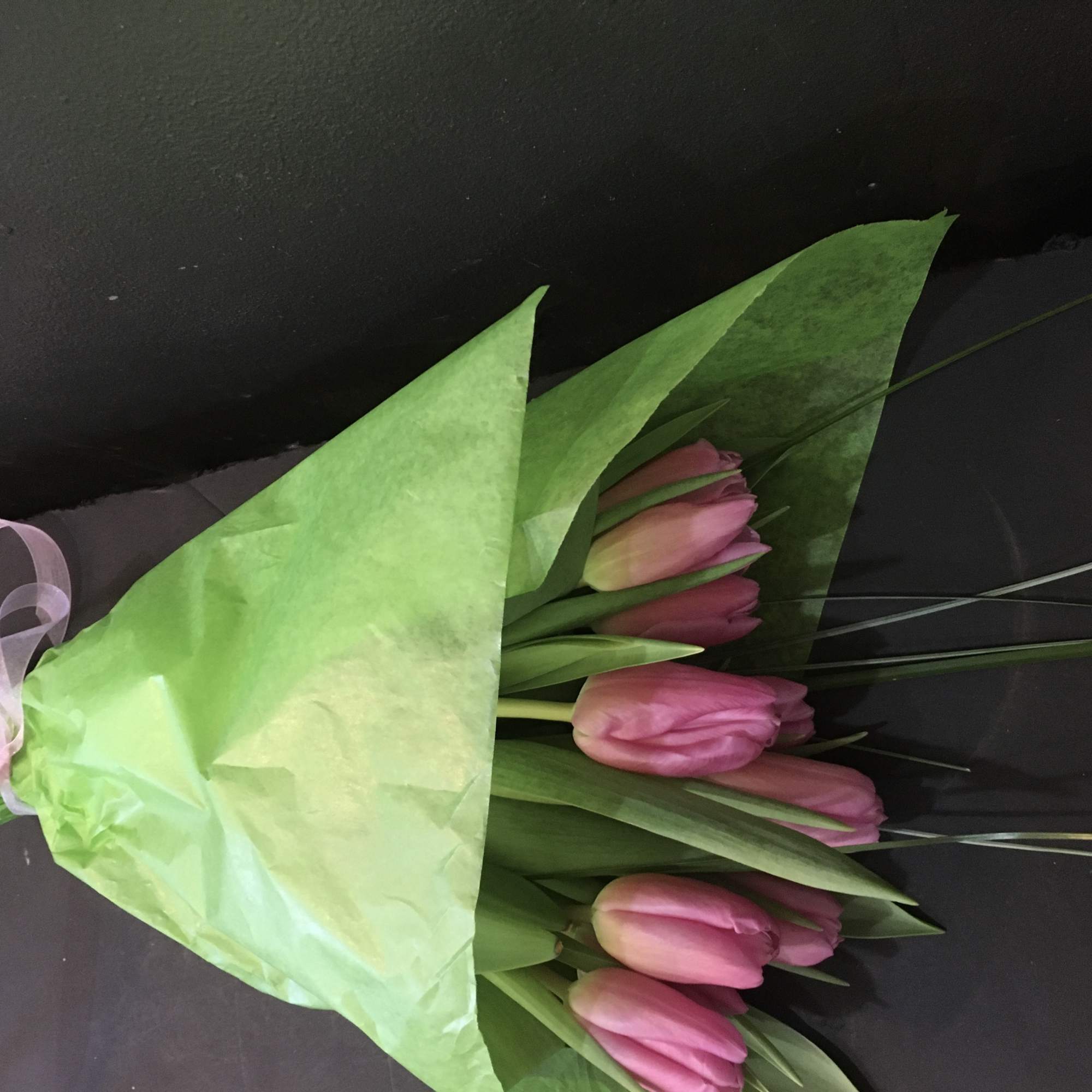 Ribbon wrapped bunch of tulips with greenery. Does not include a vase.