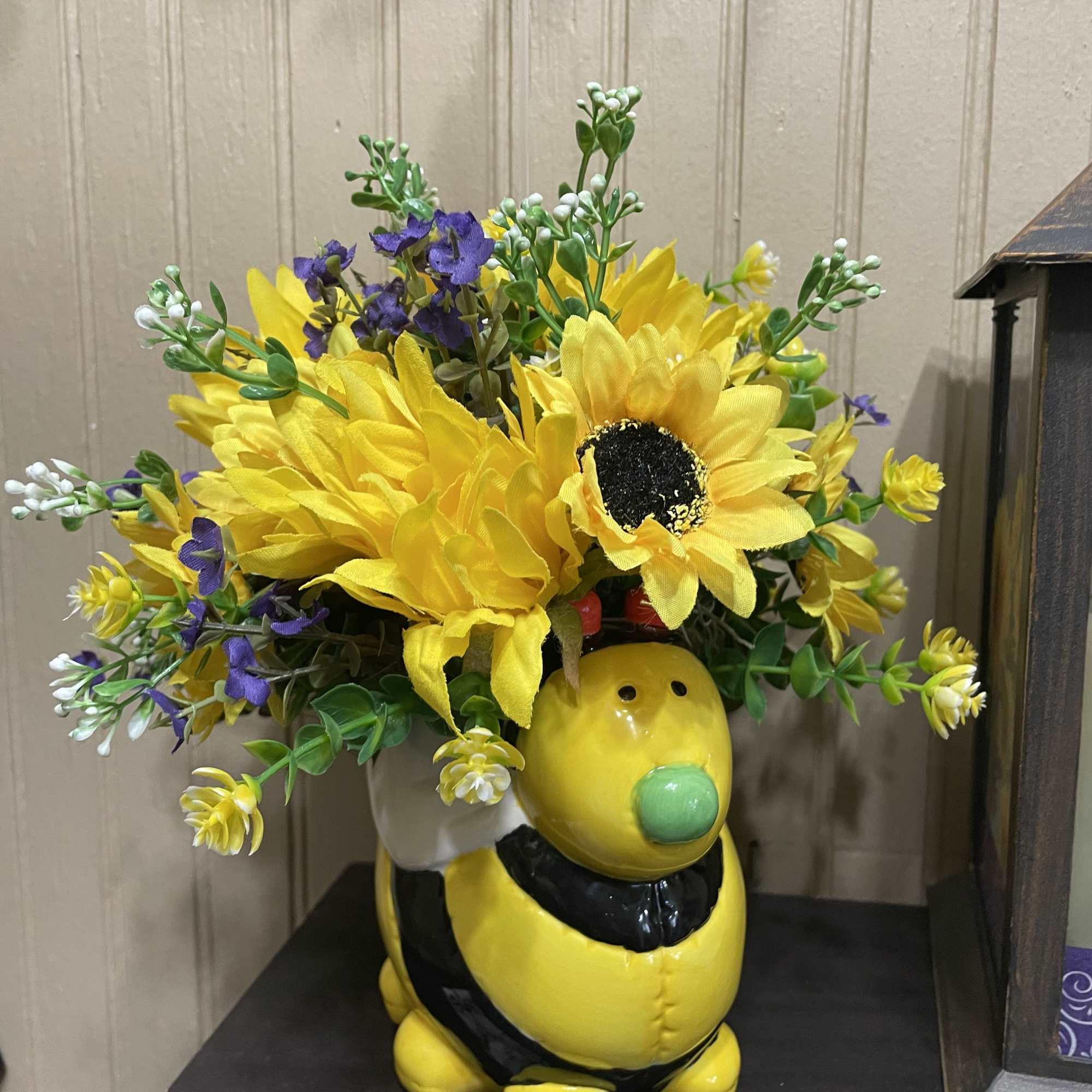 The cutest ceramic bee surrounded by silk flowers in lovely shades.. All
