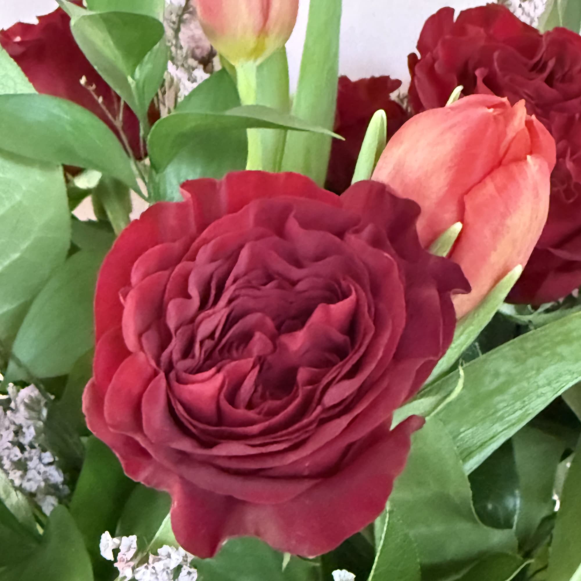 Garden Roses, tulips, seasonal greens and limonium.