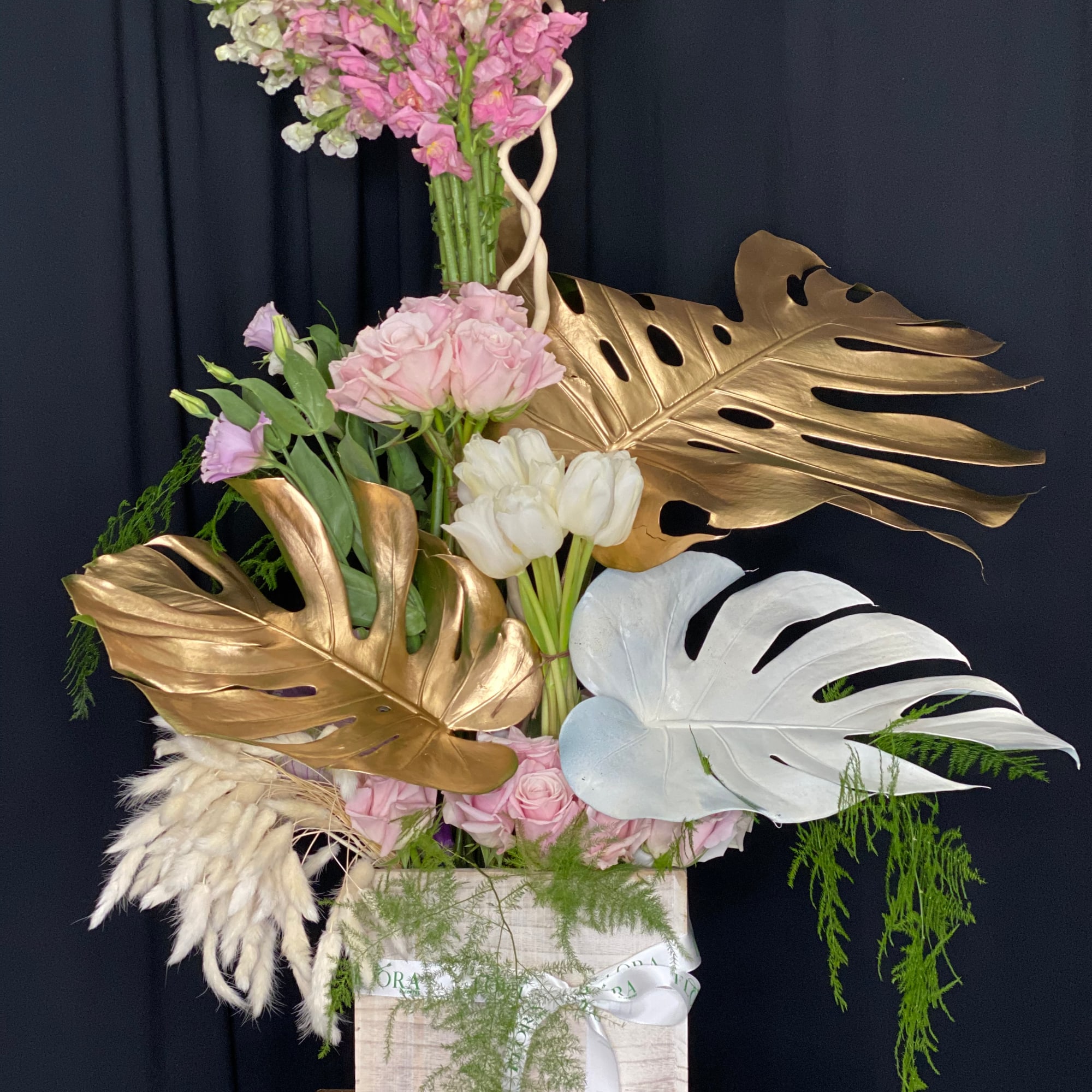 Stunning floral arrangement featuring Monstera leaves, elegant roses, and vibrant snapdragons. Perfect