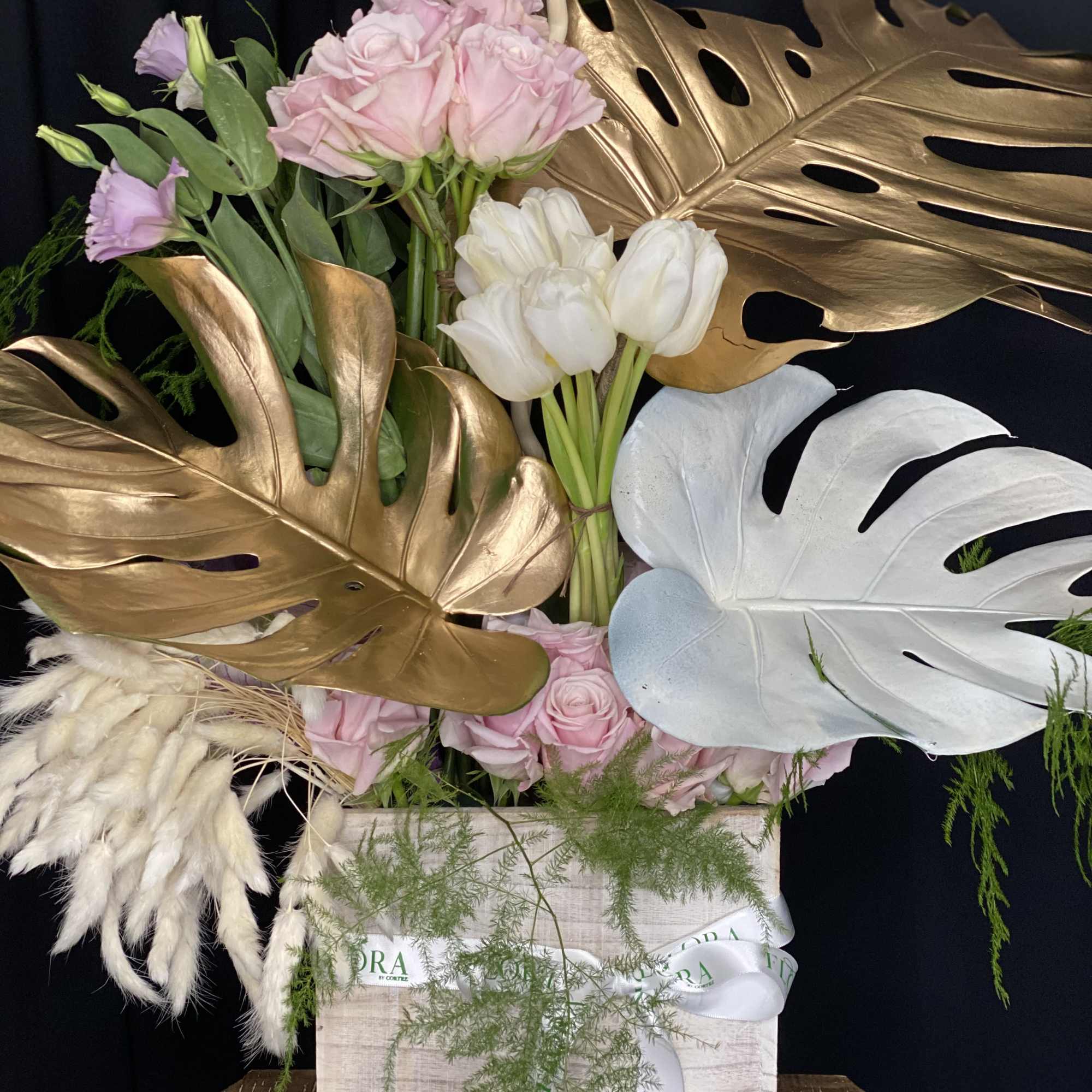 Stunning floral arrangement featuring Monstera leaves, elegant roses, and vibrant snapdragons. Perfect