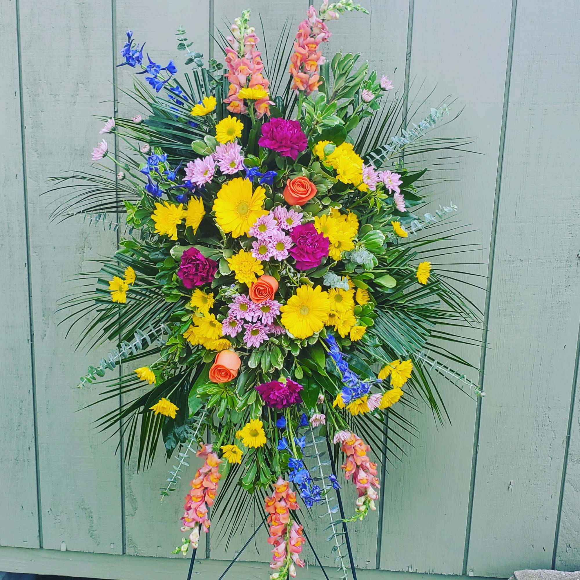 One standing spray arrives with orange gladioli and roses, yellow gerberas, hot
