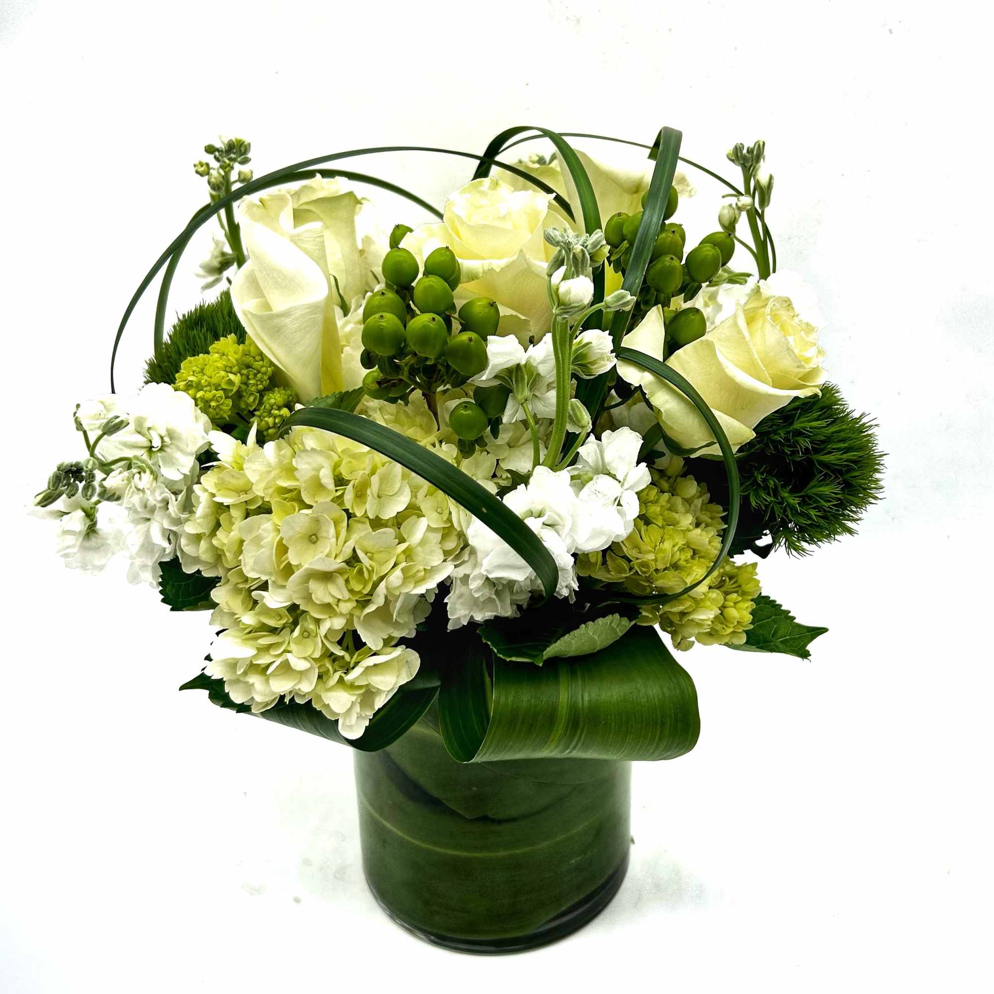 A modern all white and green floral bouquet styled in a clear
