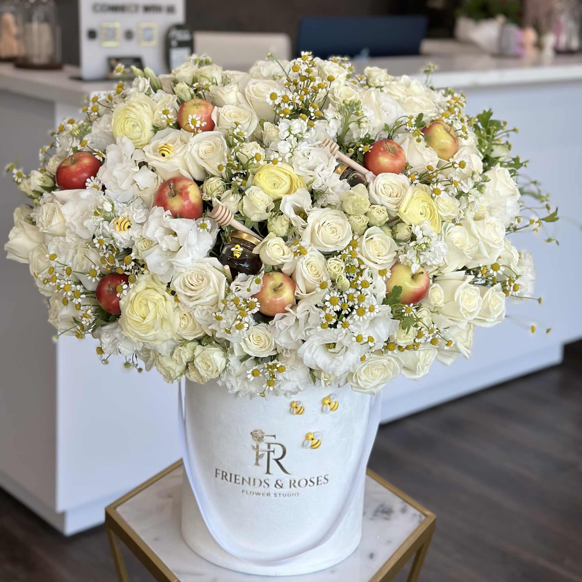 Festive arrangement of white flowers, fresh apples, and honey in our signature