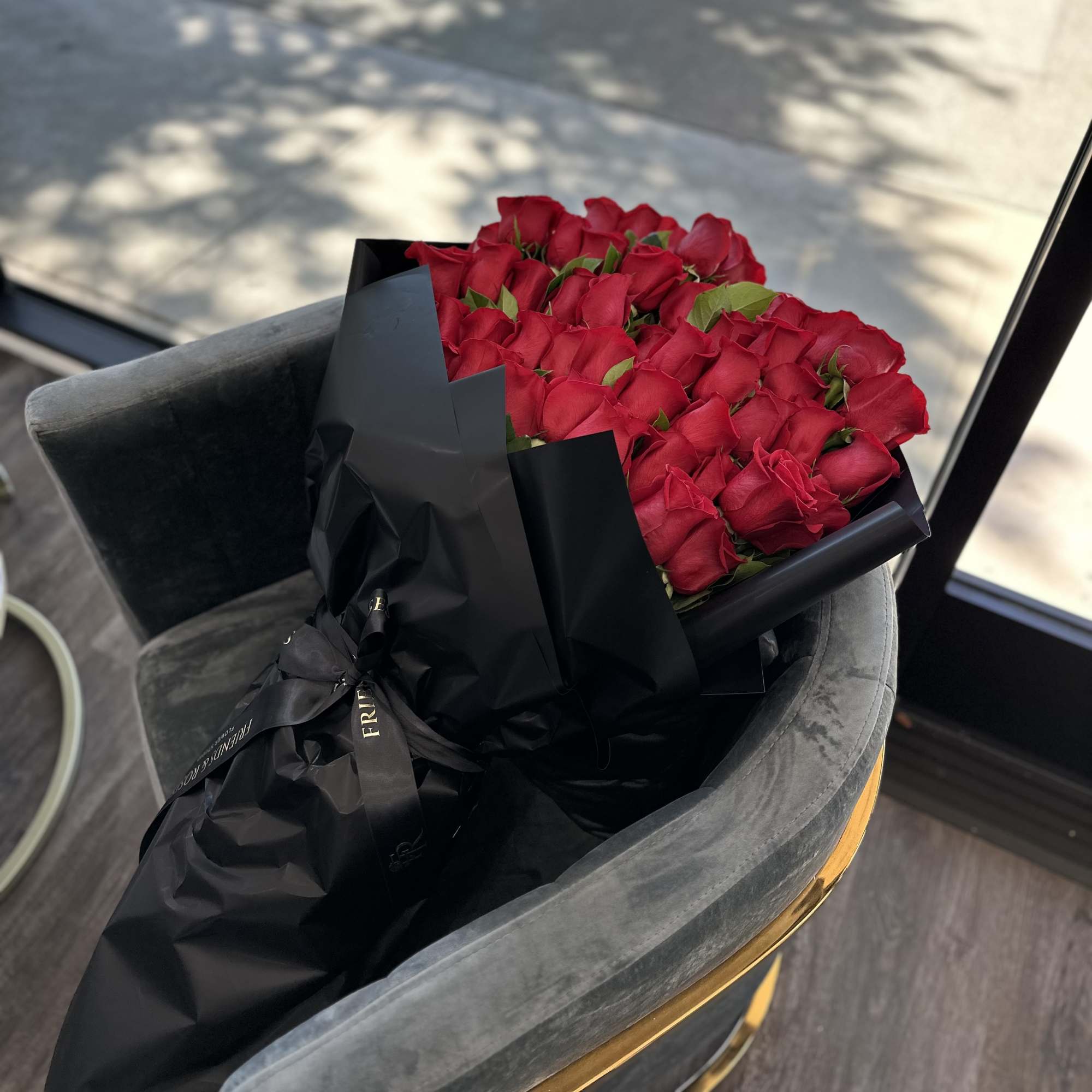 A gorgeous handcrafted bouquet of  red roses in a wrapping black