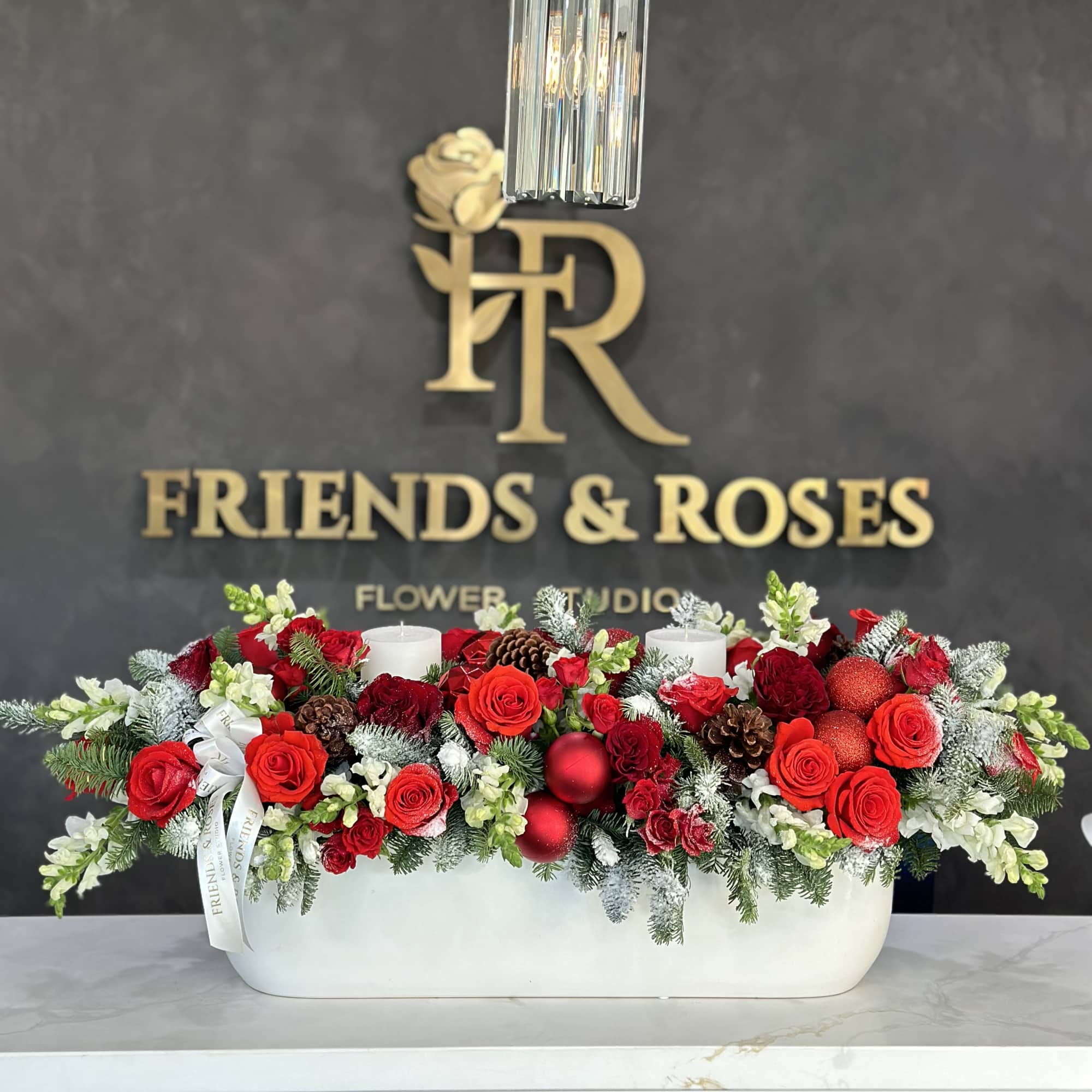 Gorgeous vase arrangement of fresh flowers, Christmas balls, and pillar candles for