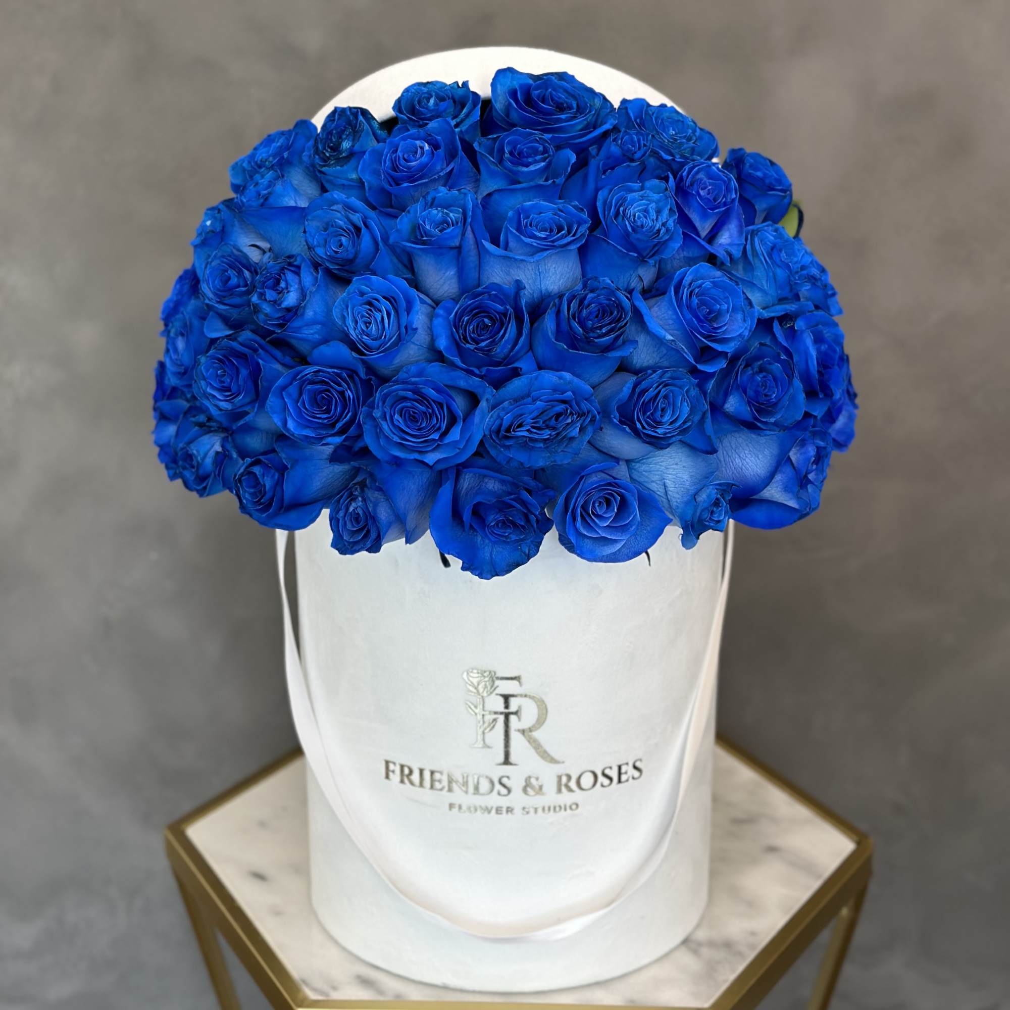 A stunning and unique arrangement of blue roses in a white signature