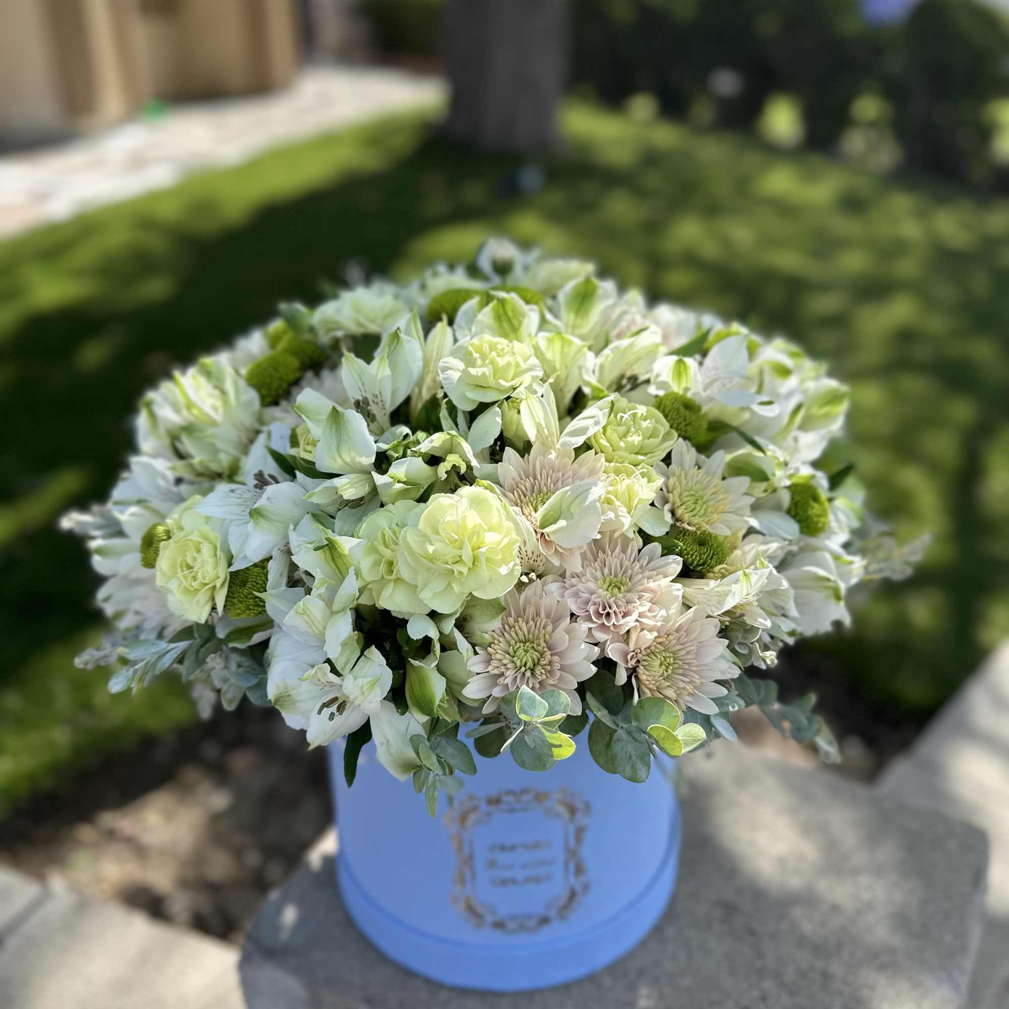A fresh and elegant floral arrangement in a soft blue box. Featuring