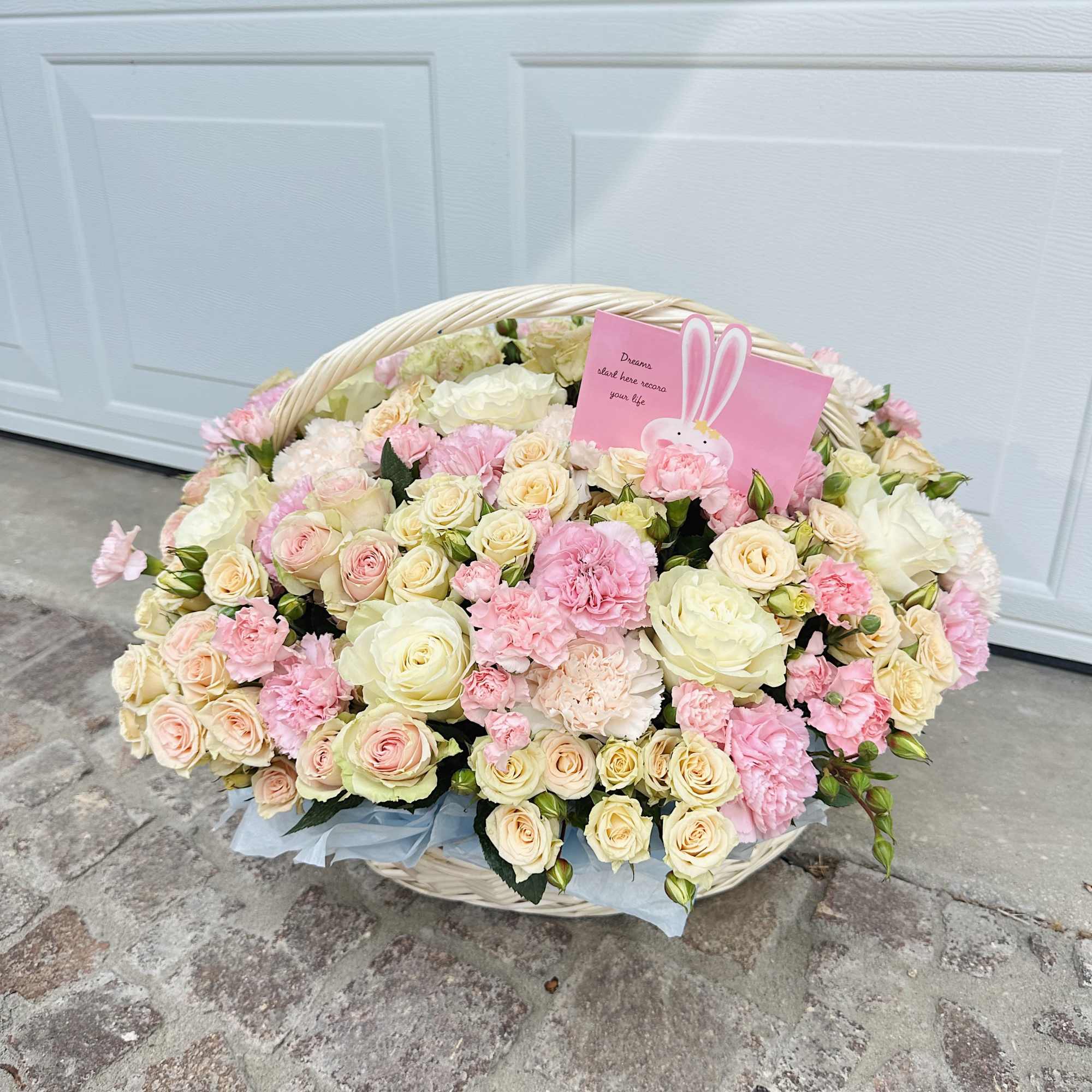 This refined arrangement in a woven basket is filled with the softest